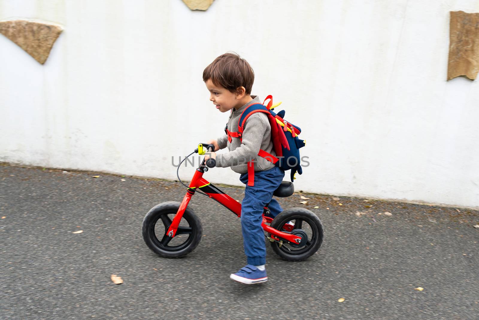Little boy rides his balance bike by dutourdumonde