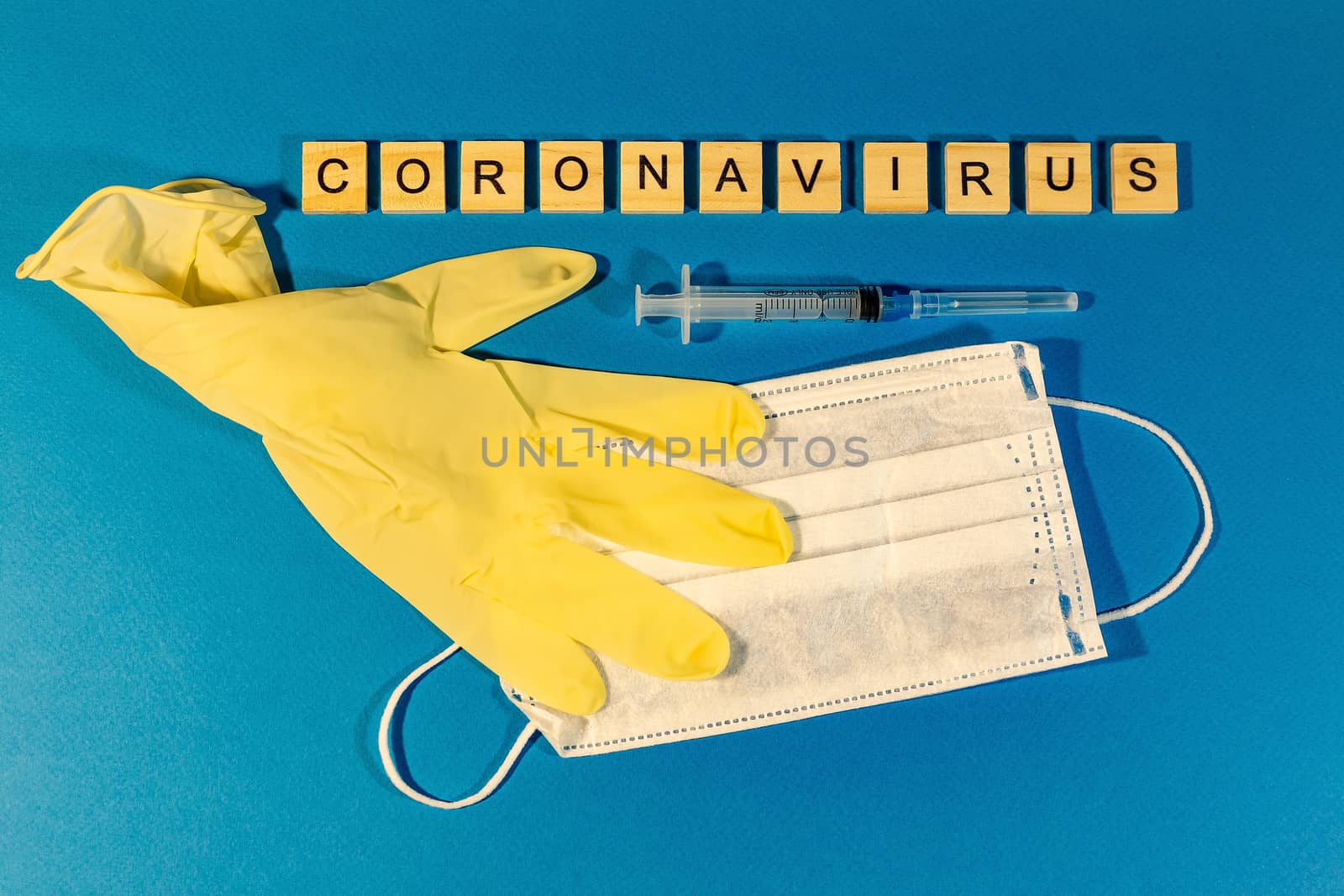 Medical mask, medical gloves and letters on the blue surface. The concept of coronavirus, flu,. The view from the top. horizontal orientation. by Pirlik