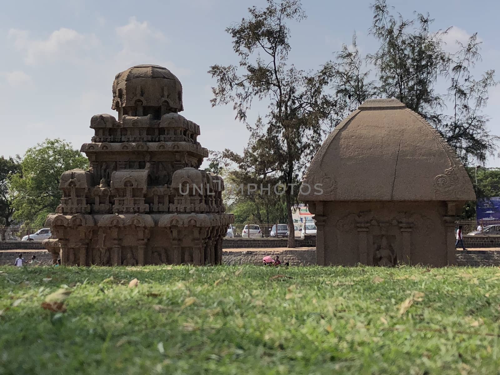 Pancha Rathas is an example of monolith Indian rock-cut architecture. Resembling a chariot ratha, it is carved out of a single, long stone of pink granite. This is one of the Group of Monuments at Mahabalipuram and also a UNESCO World Heritage Site. In this view monuments of Pancha Rathas are beautifully captures from the grass meadow area.
