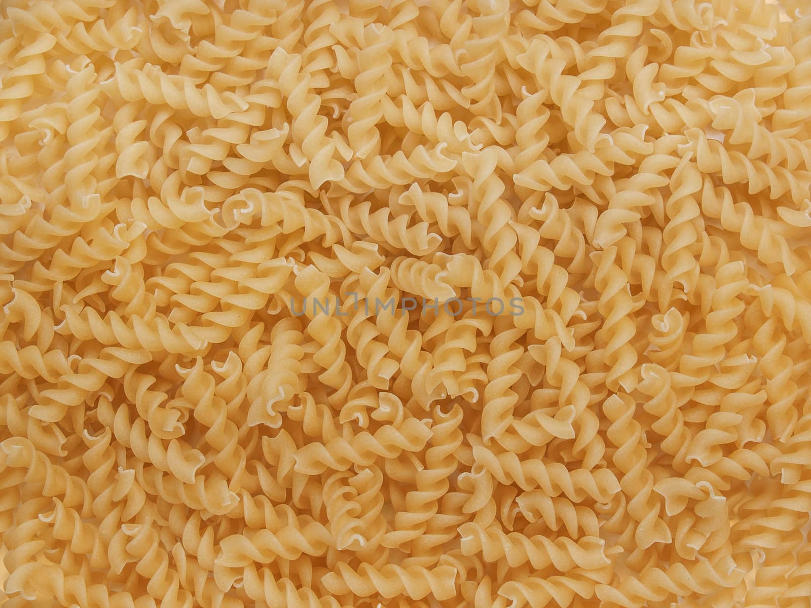 Macro curly in the form of spirals laid out on the table in the form of a background very tightly beautiful yellow appetizing ingredients for cooking
