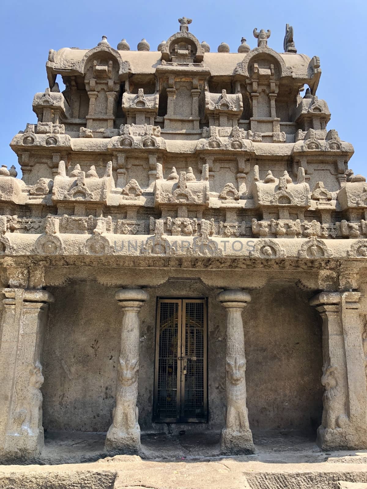 Pancha Rathas is an example of monolith Indian rock-cut architecture. Resembling a chariot ratha, it is carved out of a single, long stone of pink granite. This is one of the Group of Monuments at Mahabalipuram and also a UNESCO World Heritage Site. In this view monuments of Pancha Rathas are beautifully captures from the grass meadow area.