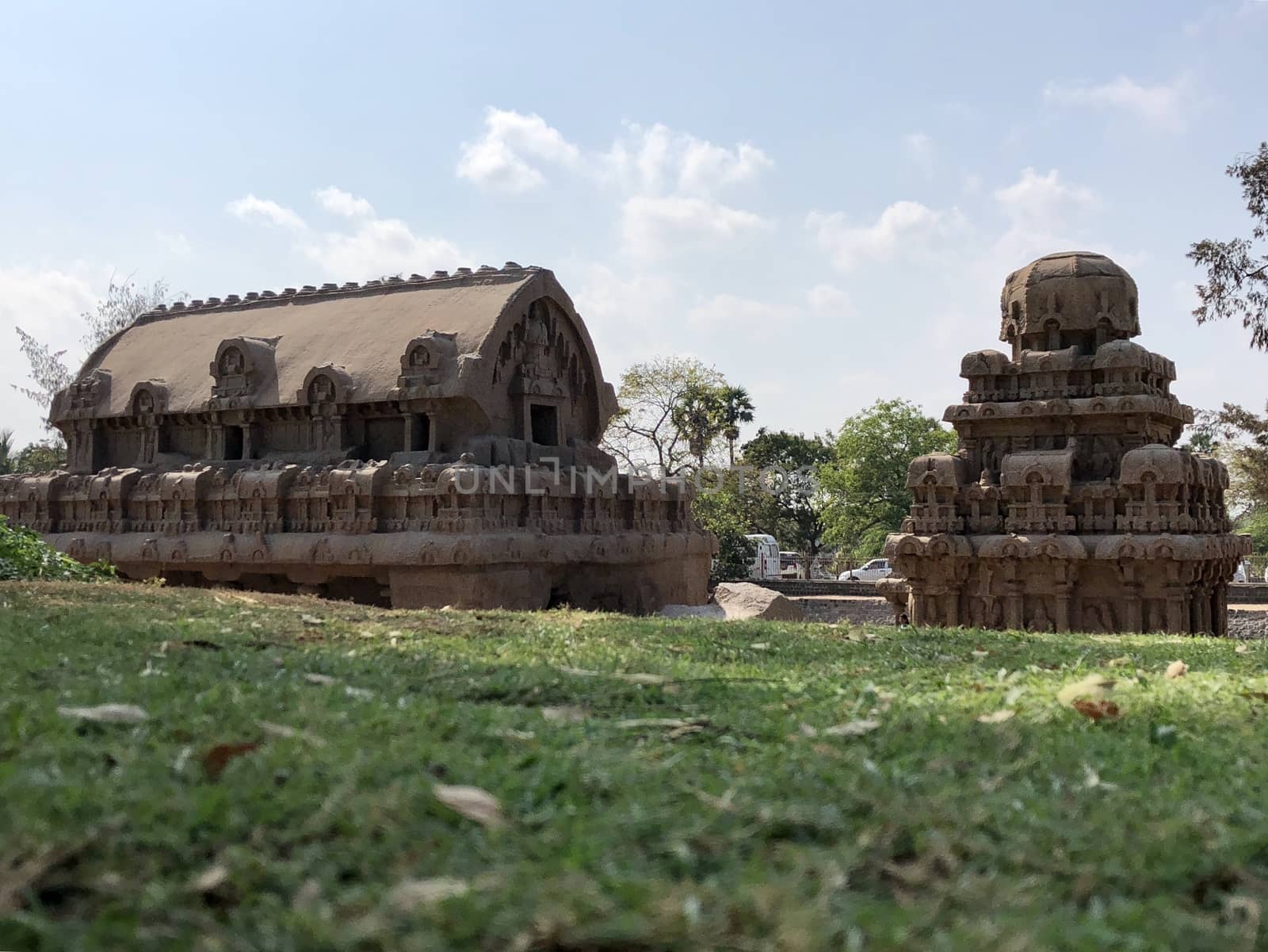 Pancha Rathas is an example of monolith Indian rock-cut architecture. Resembling a chariot ratha, it is carved out of a single, long stone of pink granite. This is one of the Group of Monuments at Mahabalipuram and also a UNESCO World Heritage Site. In this view monuments of Pancha Rathas are beautifully captures from the grass meadow area.