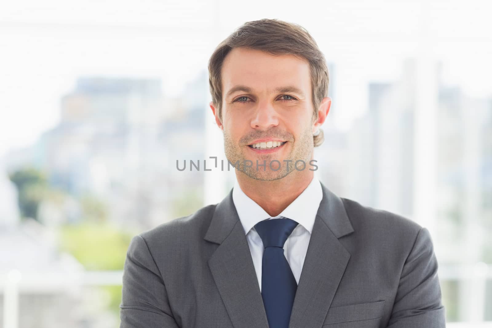 Portrait of a young businessman standing over blurred background outdoors