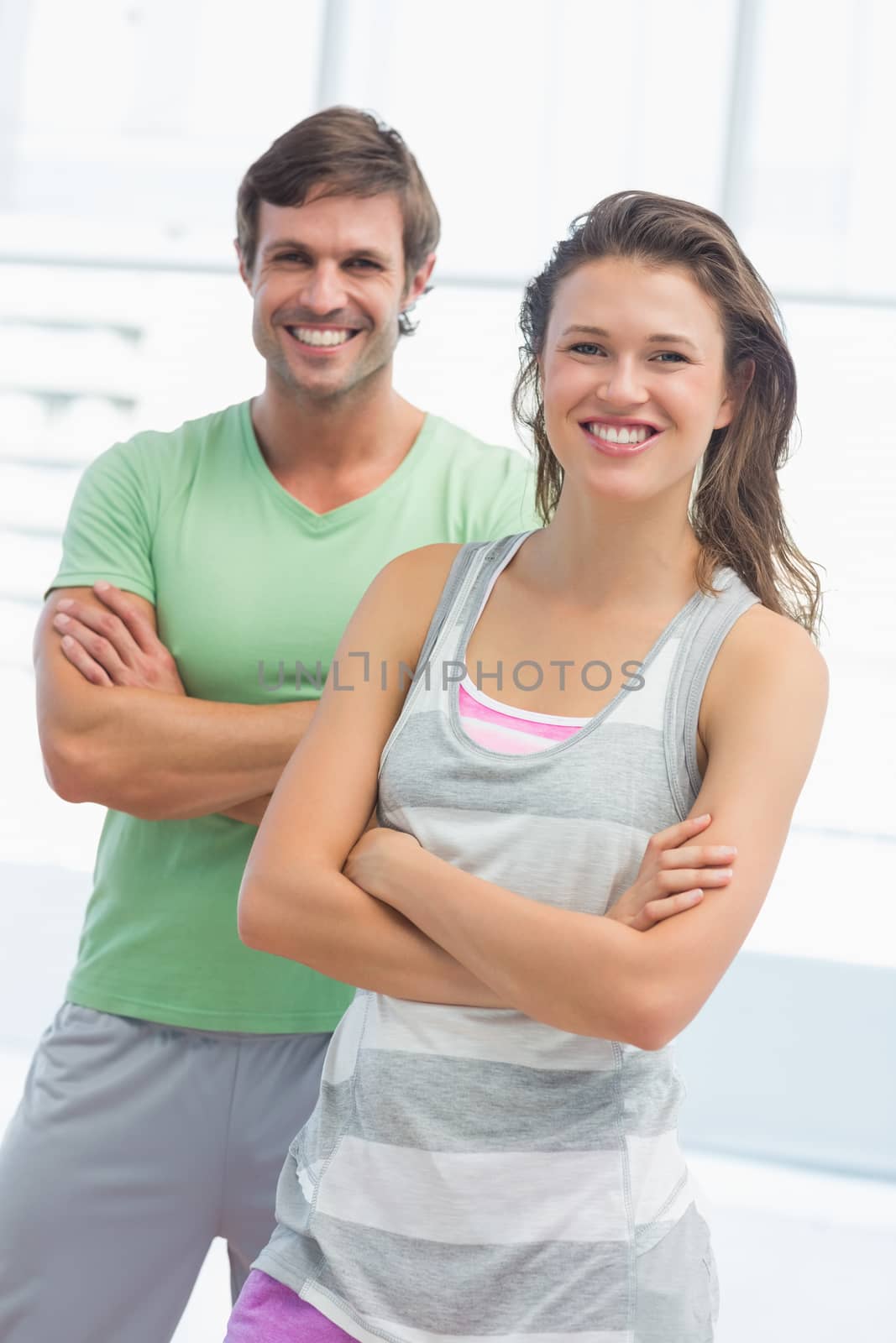 Portrait of a fit couple with arms crossed in exercise room by Wavebreakmedia