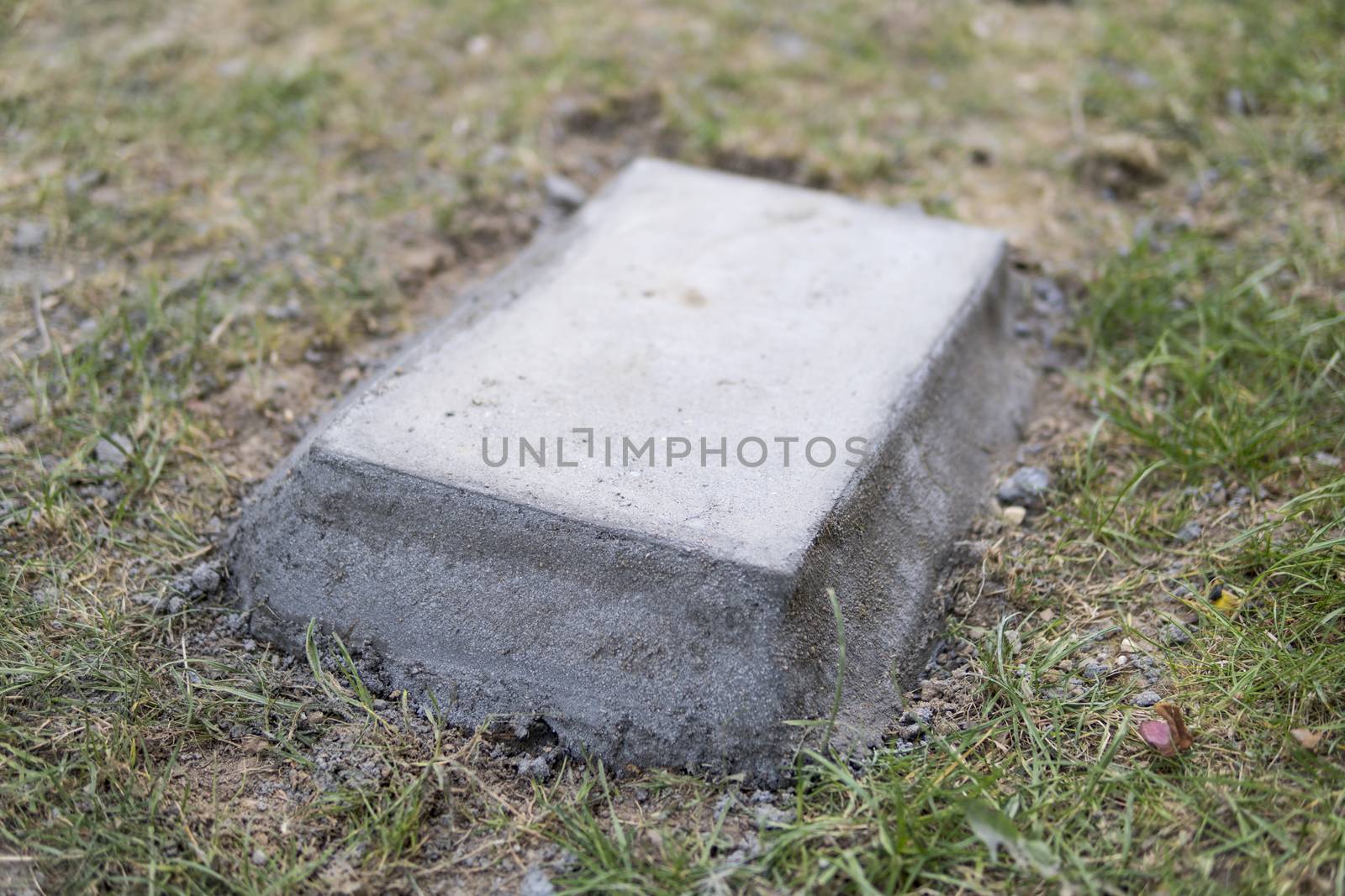 concrete block embeded on a ground surrounded by grass