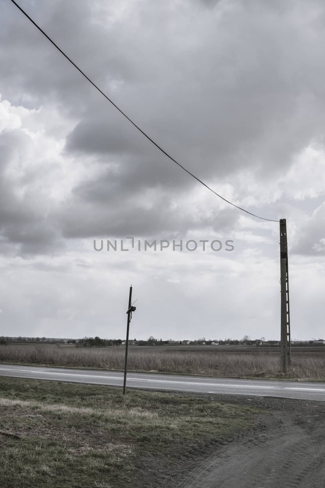 landscape with holy cross and power line pole over dark clouds