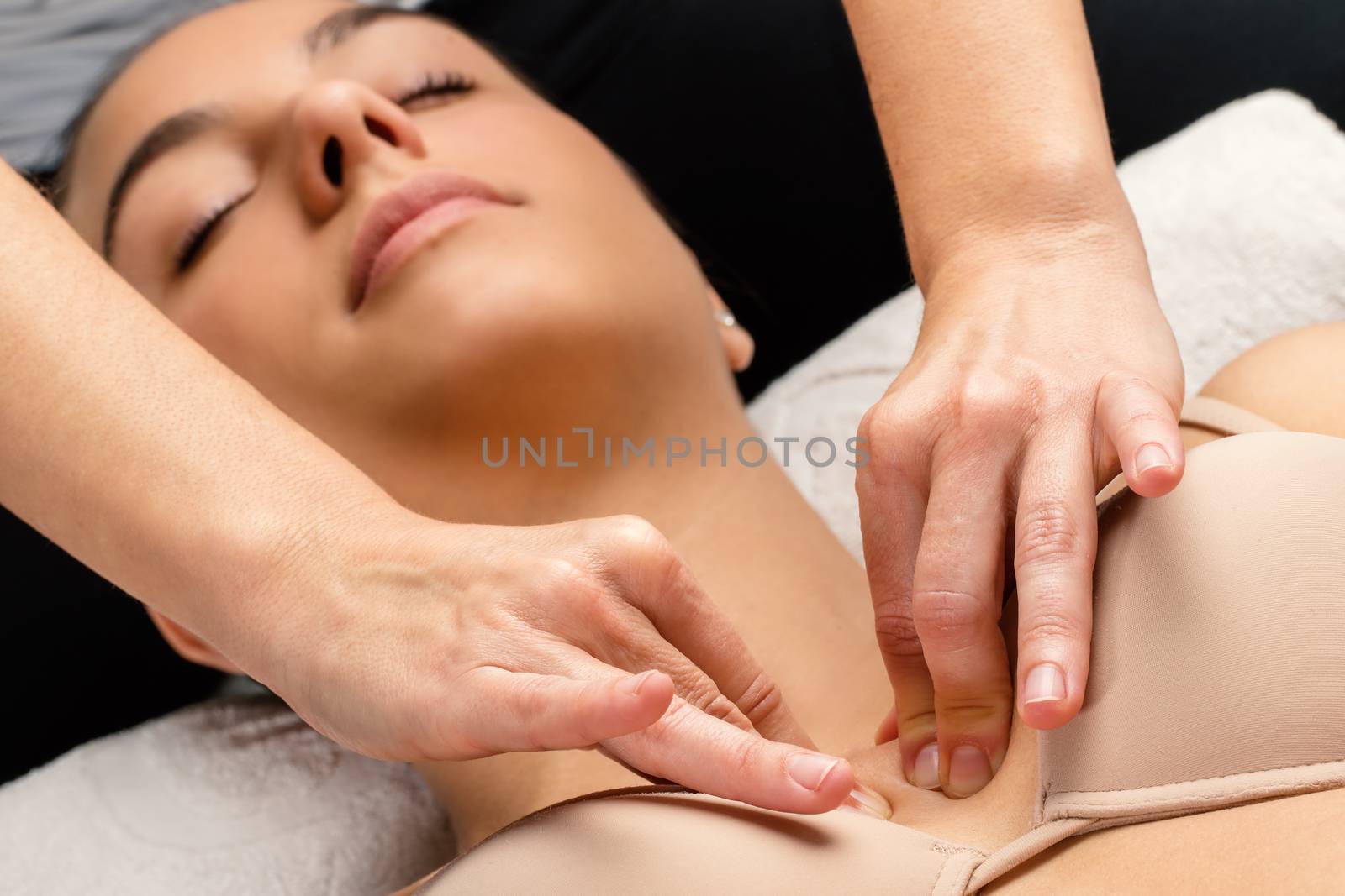 Close up portrait of woman having kinesiological therapy. Hands applying pressure on chest.