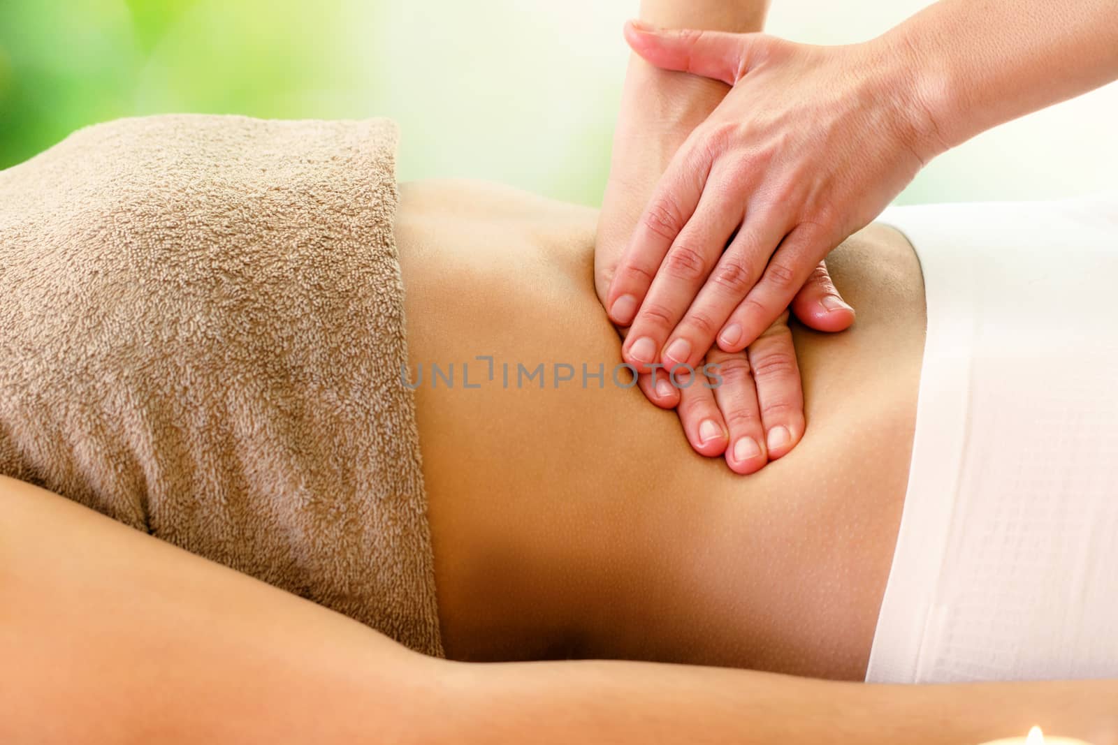 Macro close up of kinesiologist applying pressure on stomach.Detail of hands massaging belly.