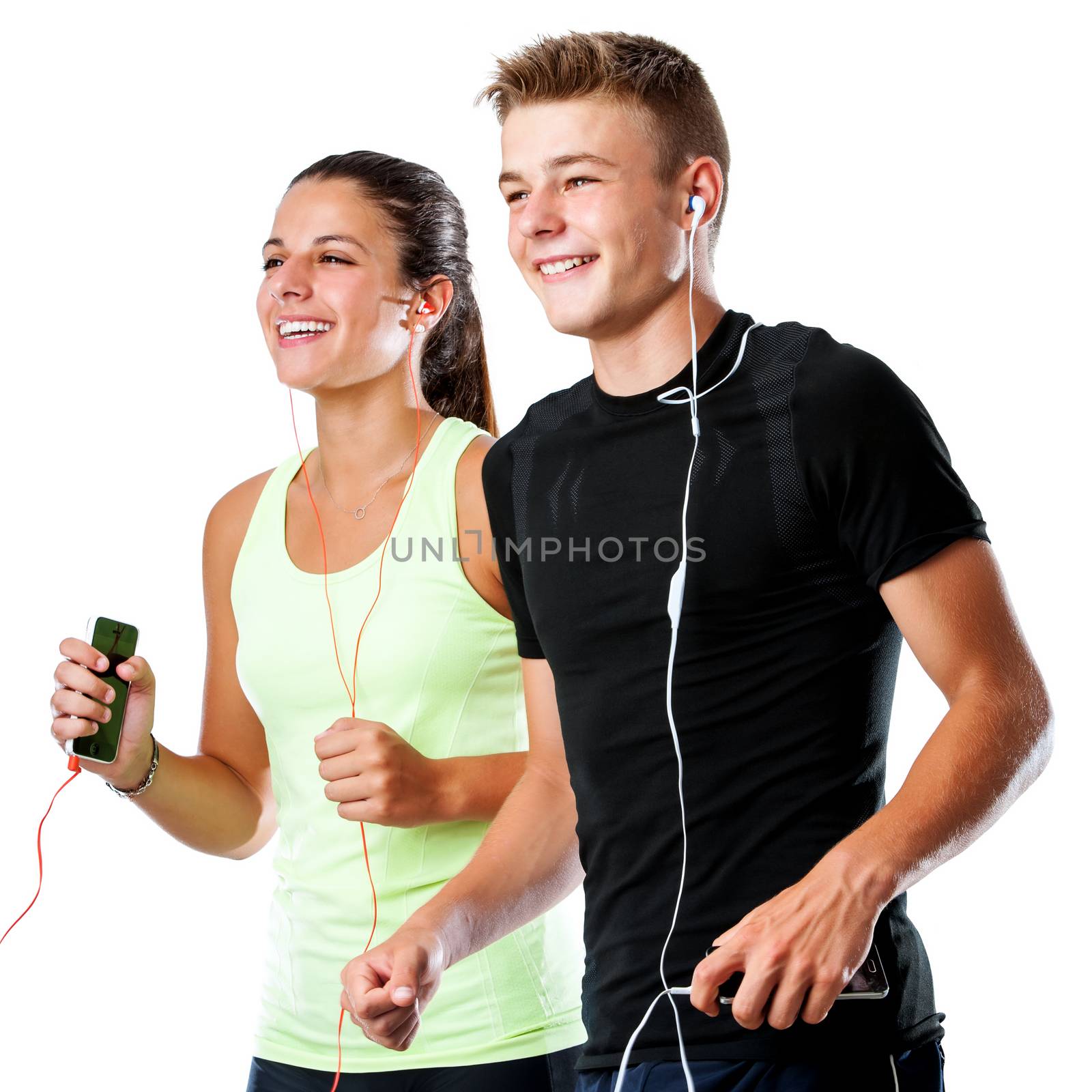 Close up portrait of active teen couple doing fitness workout together.Couple jogging together with smart phones and earphones isolated on white background.