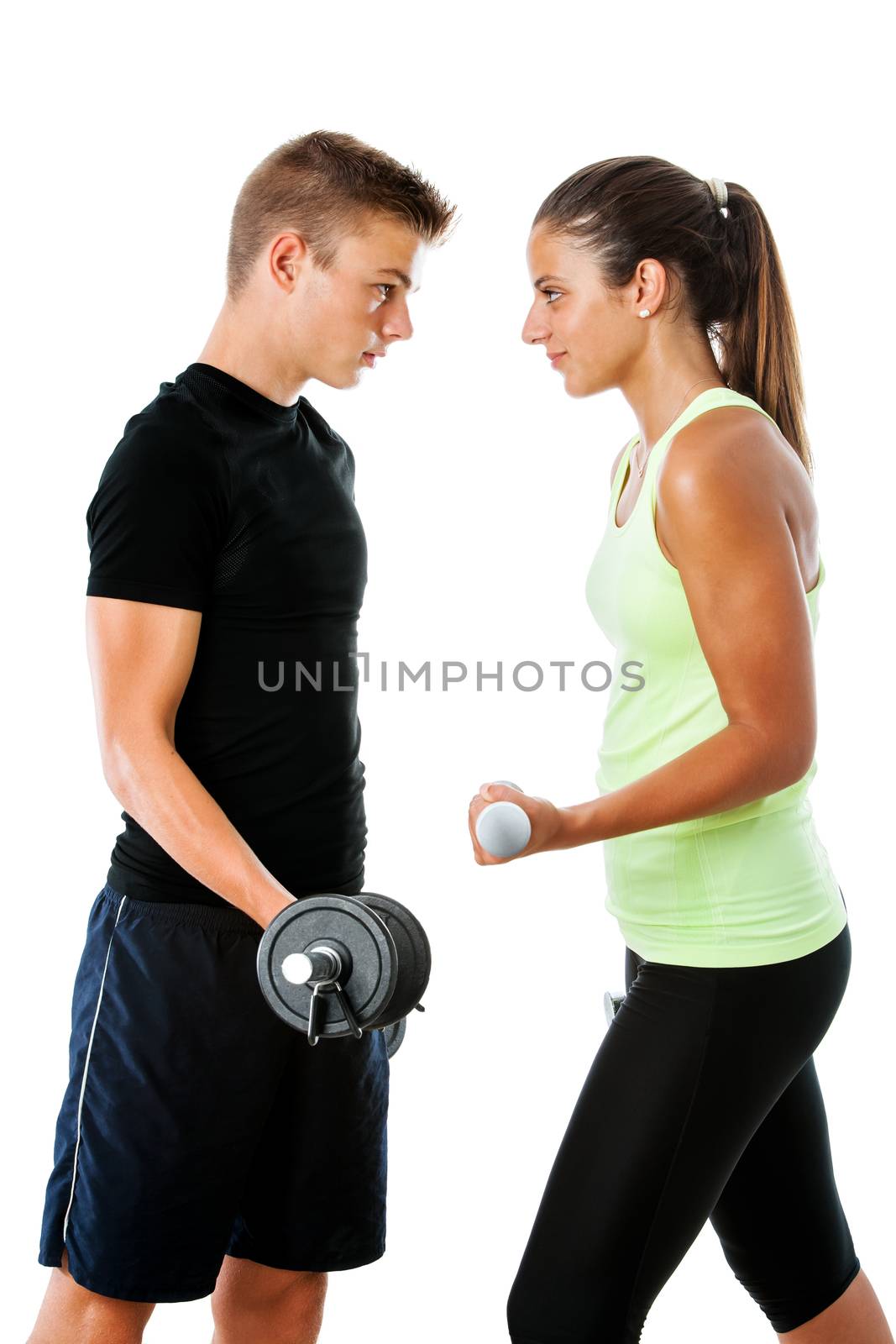 Close up portrait of Teen couple having fitness challenge.Face to face side view of couple with serious facial expressions.Isolated on white background.