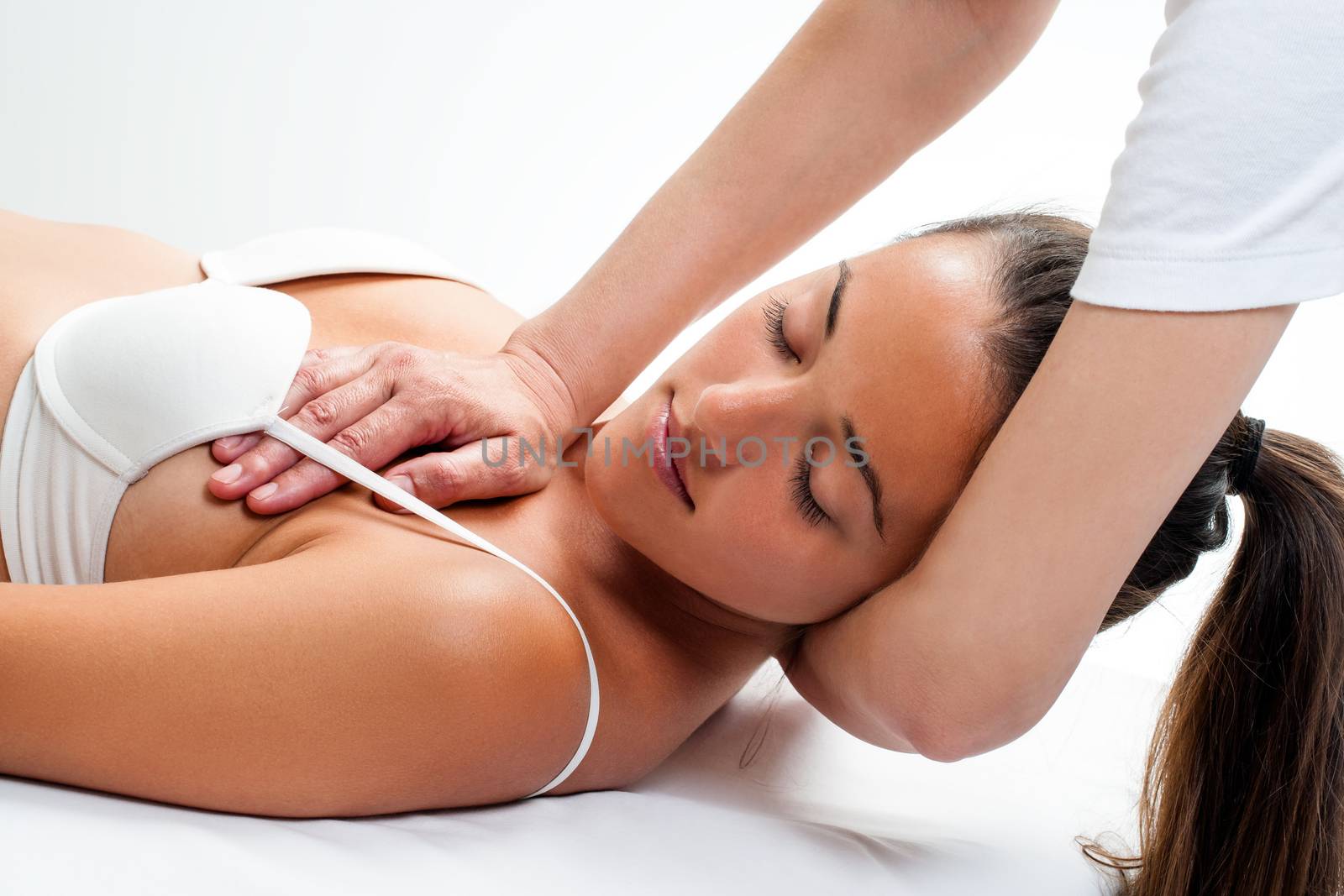 Close up of woman having osteopathic neck massage. Therapist’s hands doing manipulative treatment on neck and chest.