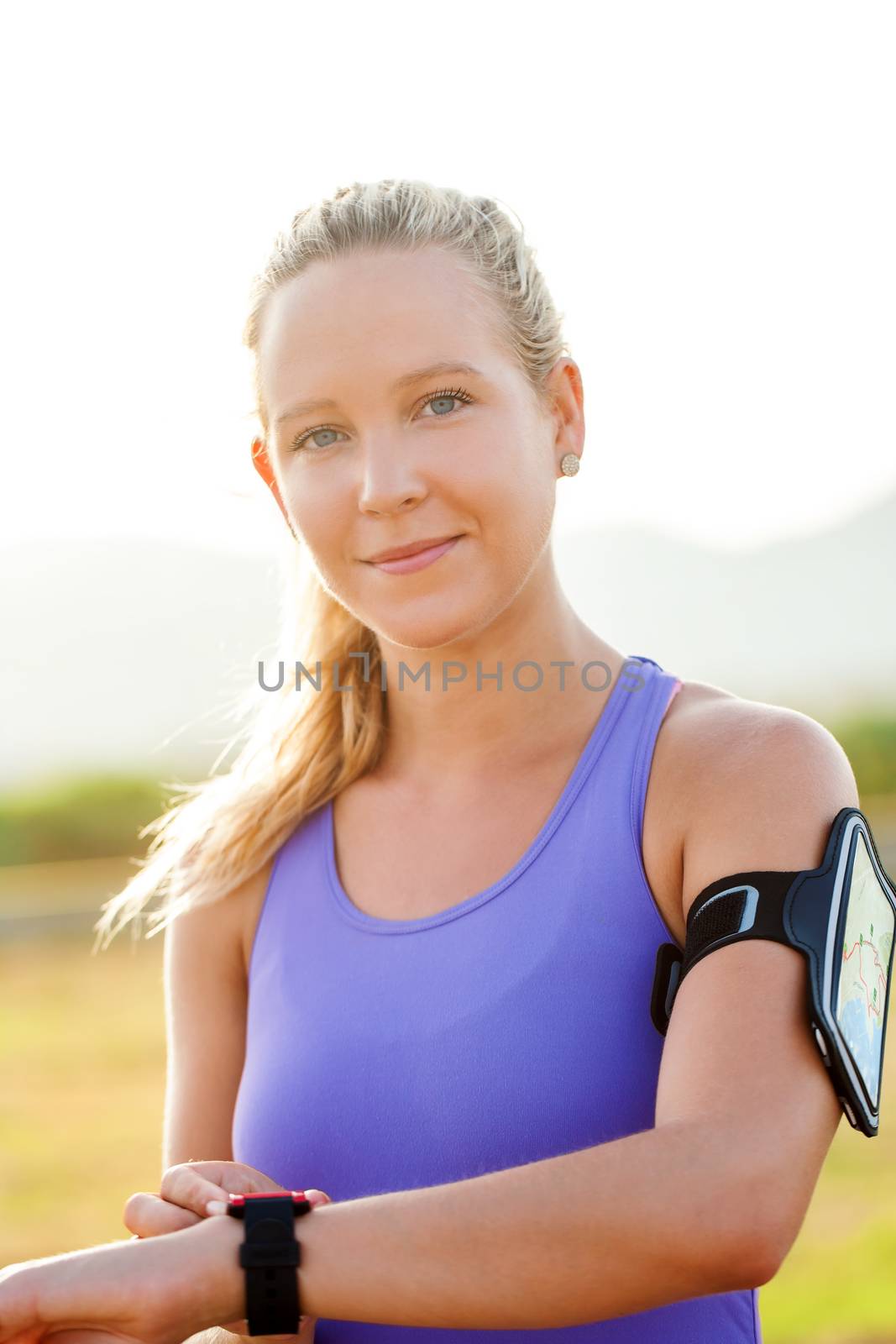 Close up portrait of attractive young woman wearing smart watch and smart watch armband. Young athlete in sport wear.