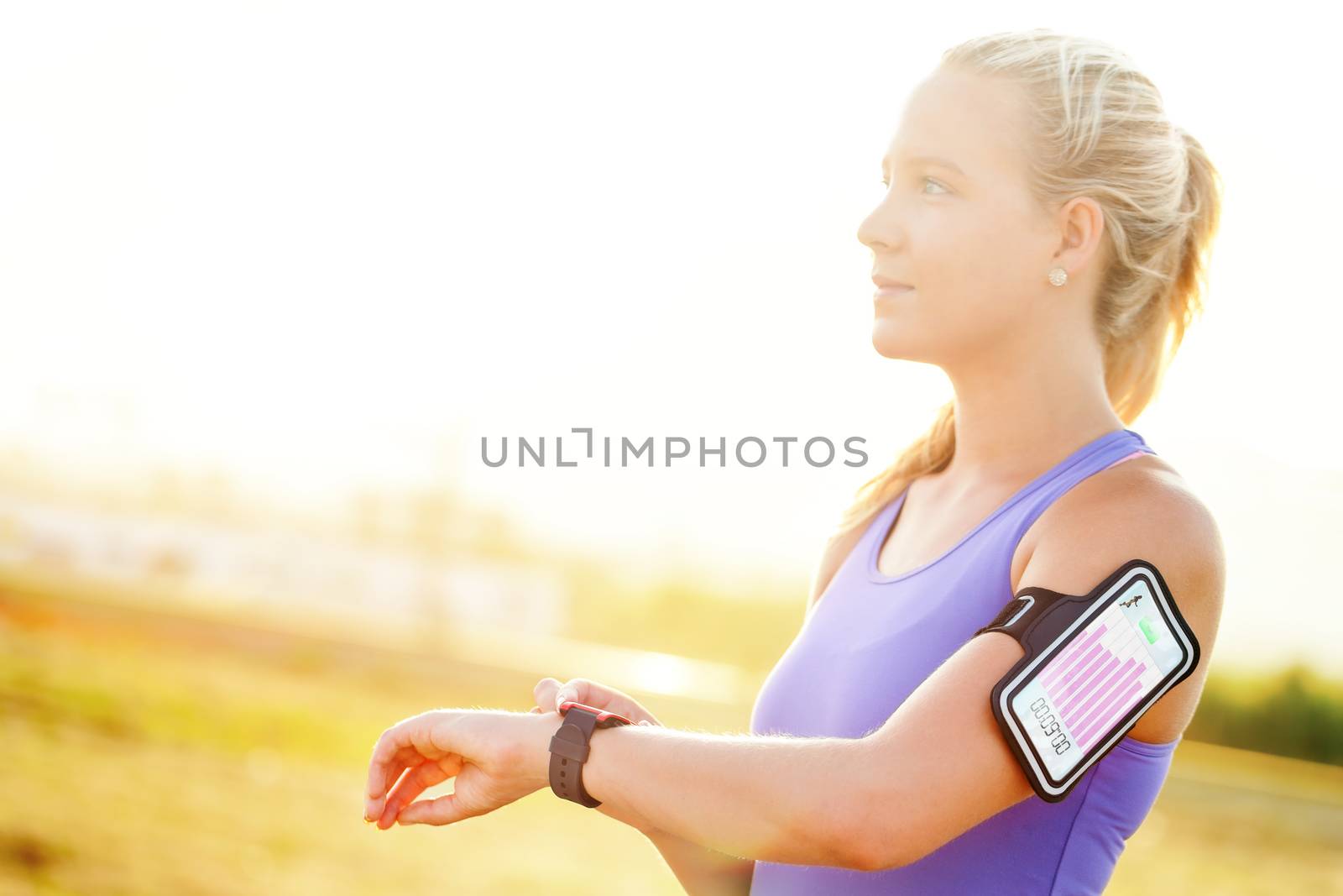 Close up portrait of attractive young woman setting workout on smart watch.Girl in sport wear with fitness chart showing on smart watch.