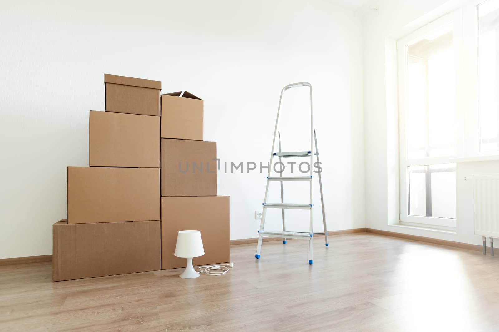 Stack of cardboard boxes for moving in interior apartment, movement or real estate concept. No people in empty room