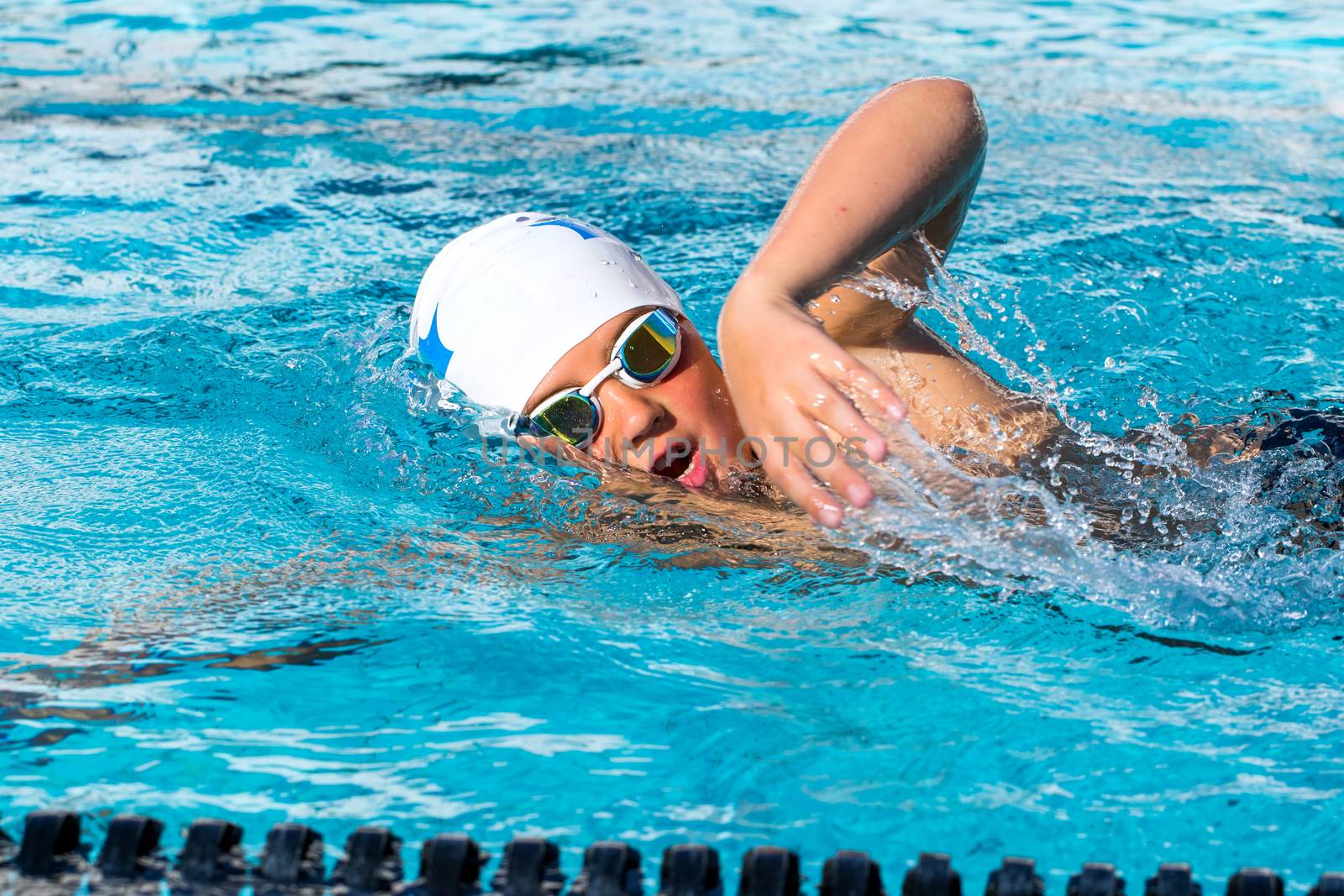 Close up action shot of teen swimmer. by karelnoppe