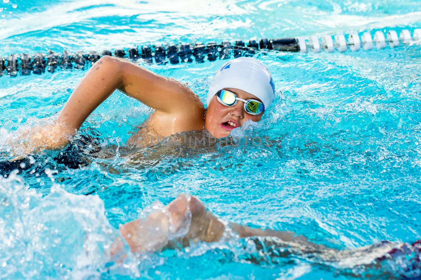 Close up action shot of teen boy competing at swimming gala.Young man doing freestyle.