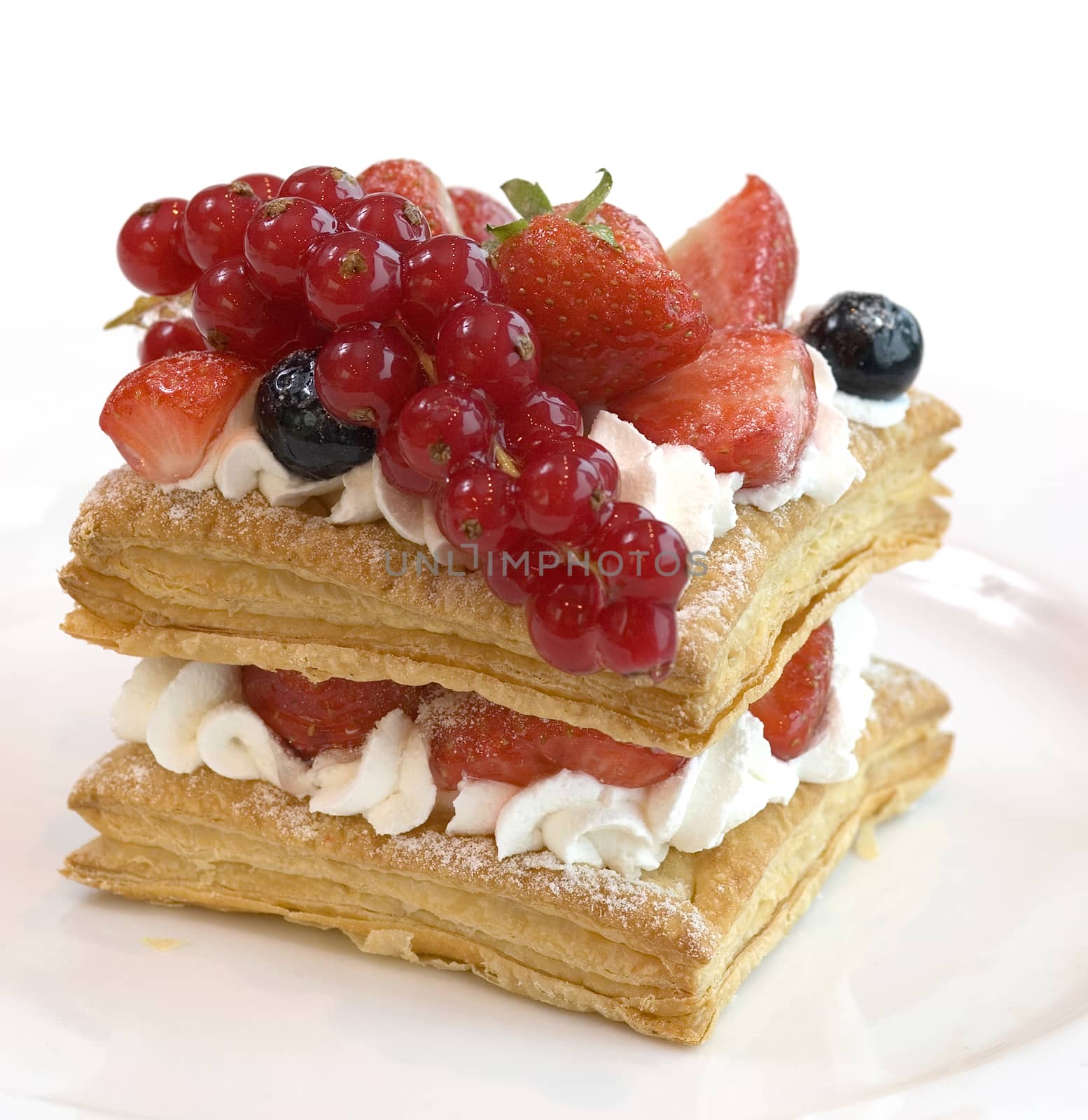 Fresh fruit cake with red currant and strawberries. Piece of cake close up view.