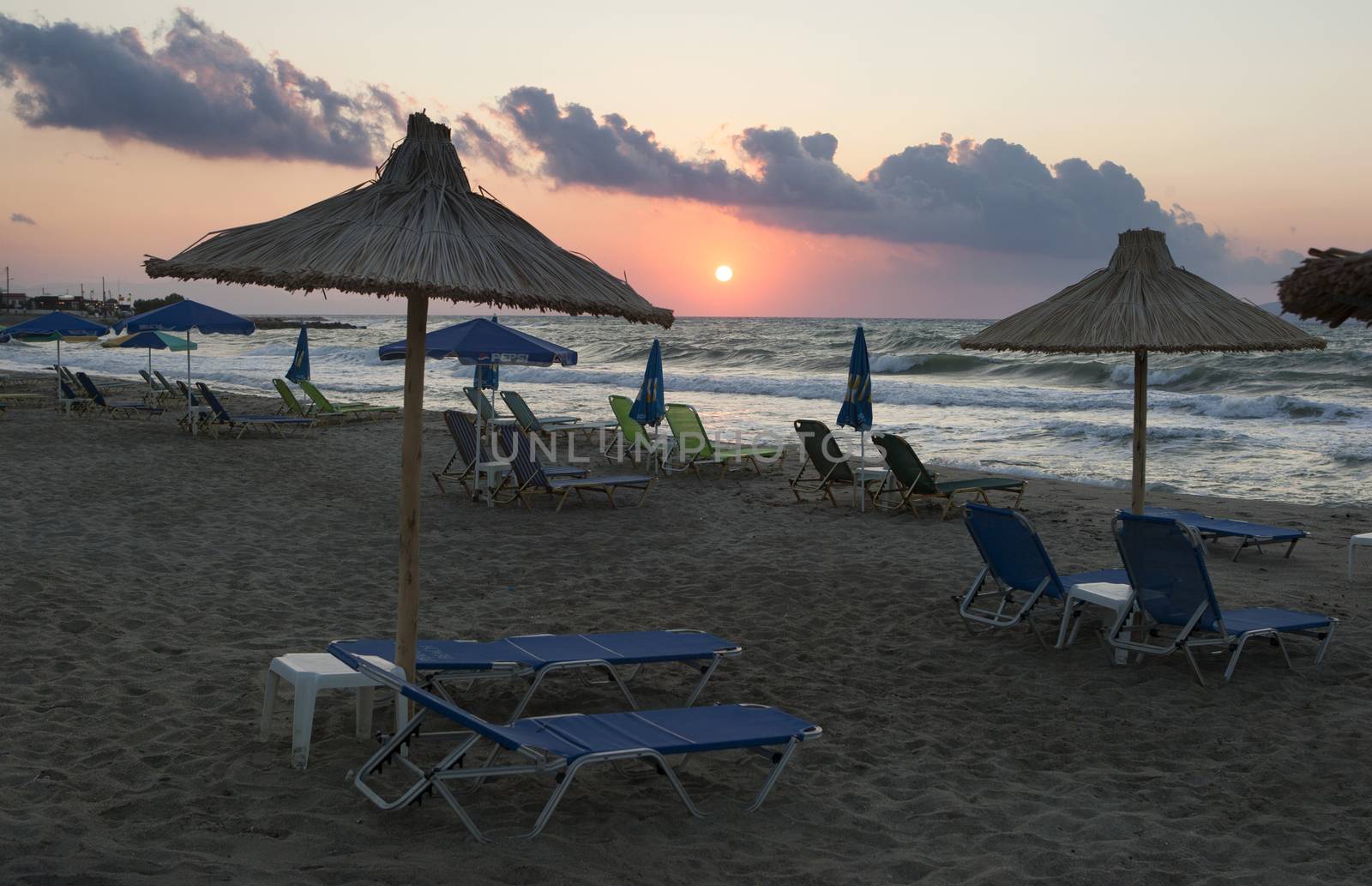 View of empty deck chairs on the beach at sunset. Tourism crisis.