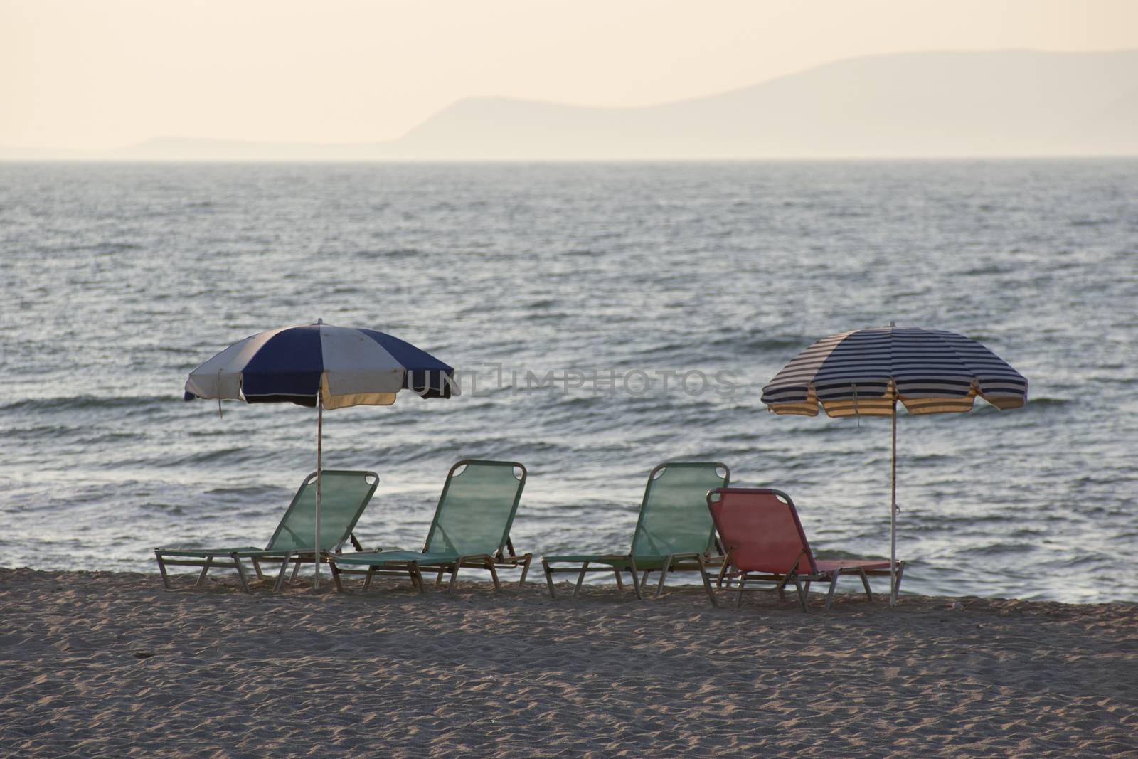 View of empty deck chairs on the beach at sunset. Tourism crisis.