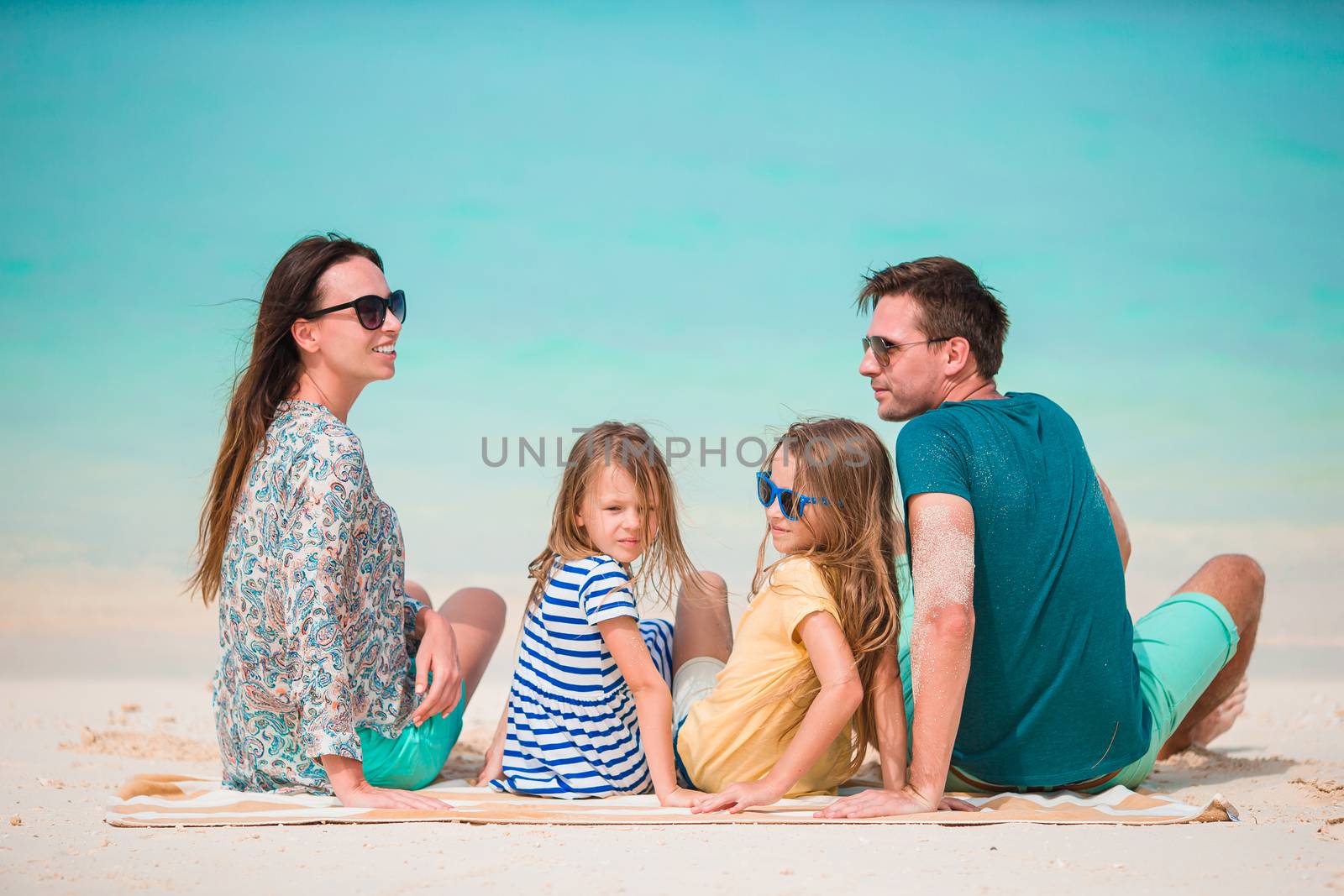 Young family on vacation on the beach by travnikovstudio