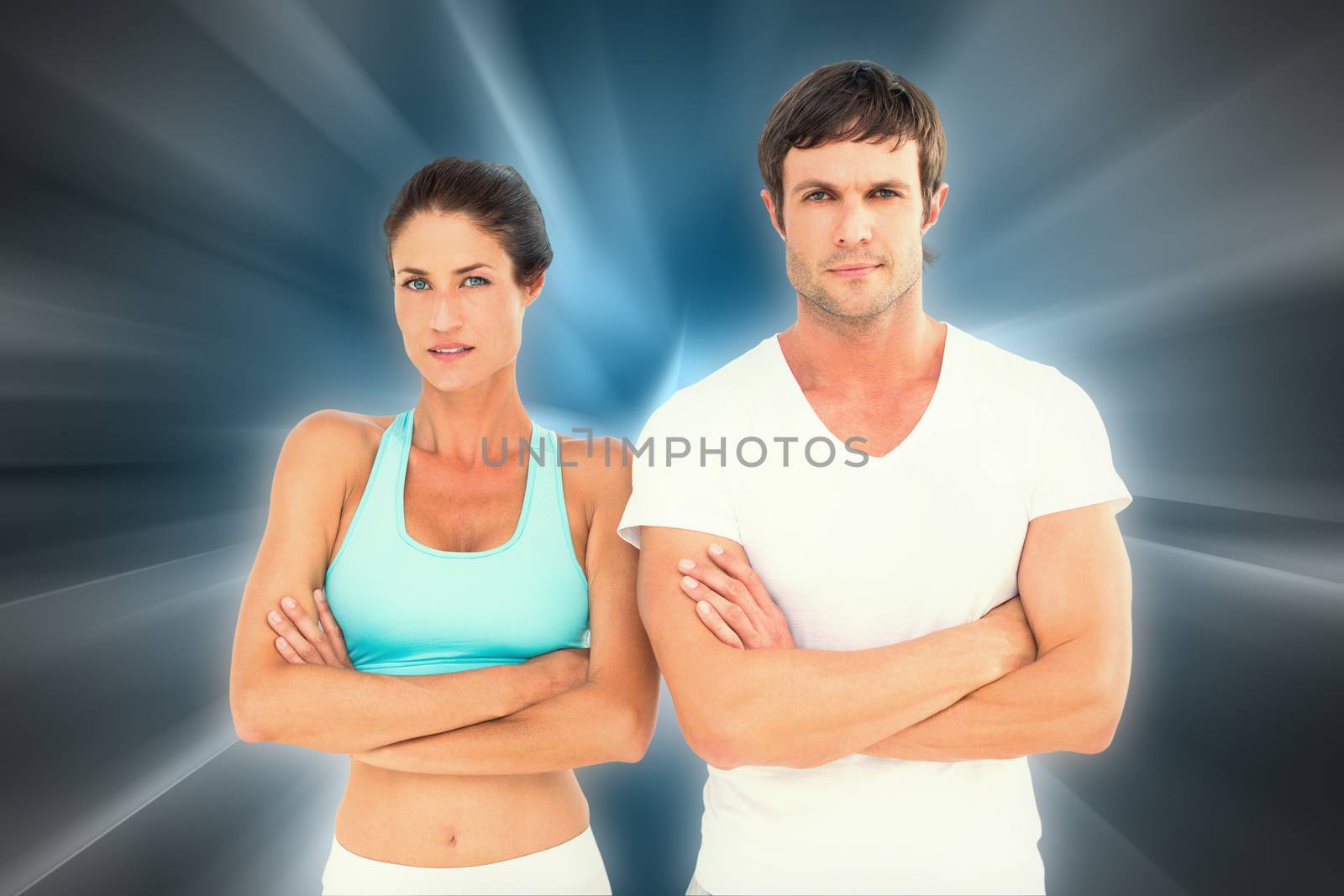 Portrait of a fit young couple with arms crossed against abstract background