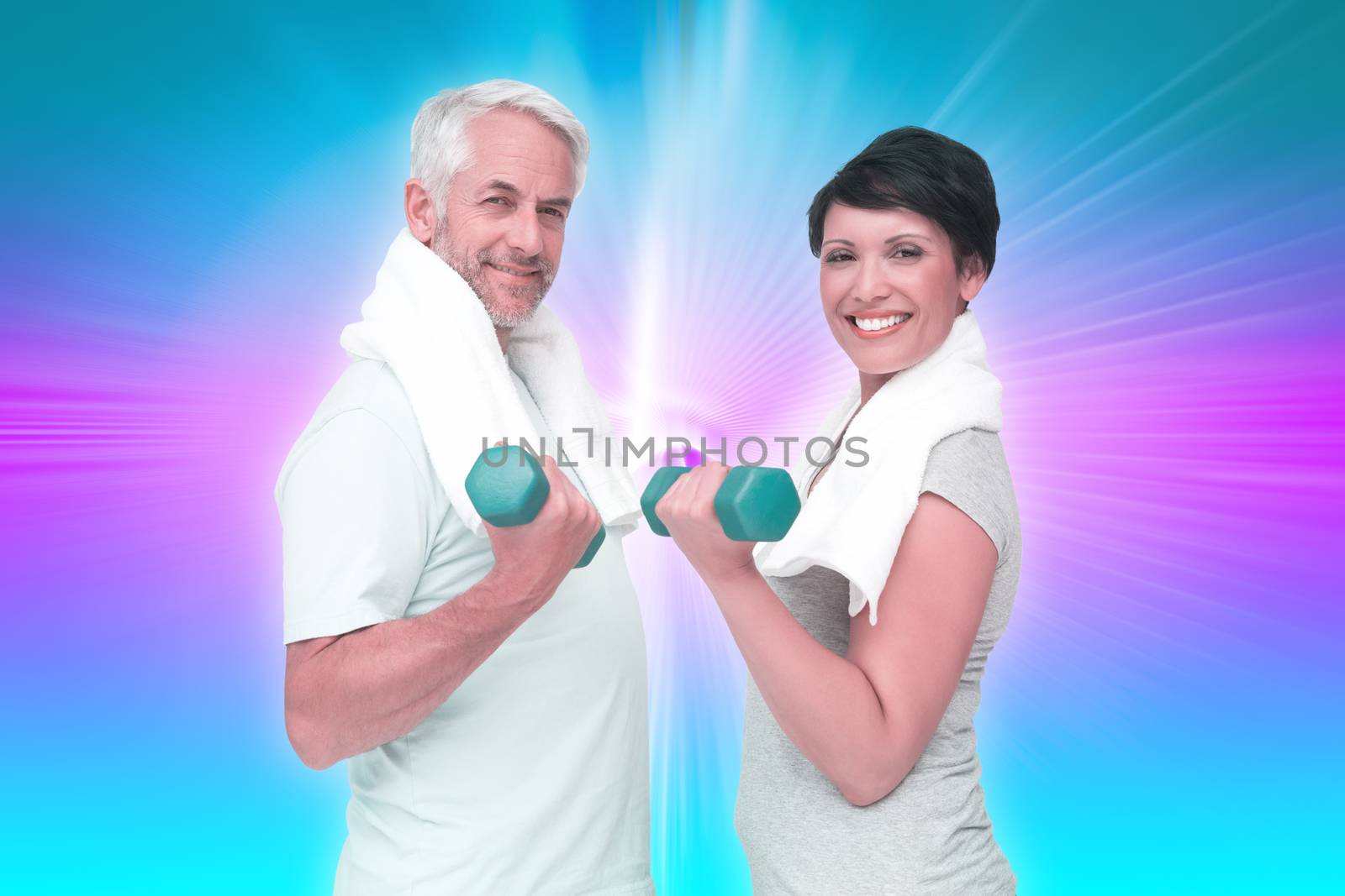 Fit mature couple exercising with dumbbells against abstract background