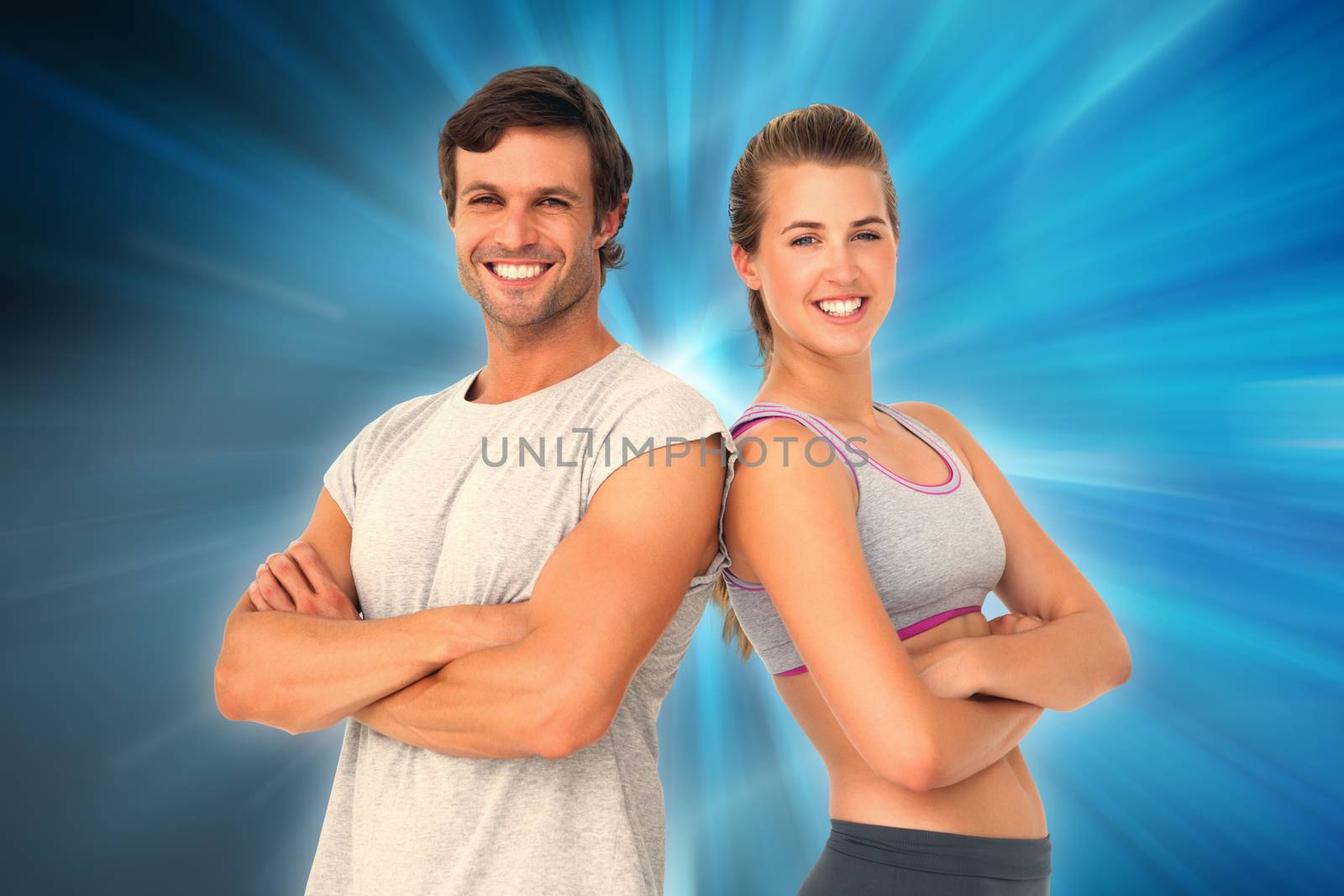 Portrait of a sporty young couple with arms crossed against abstract background
