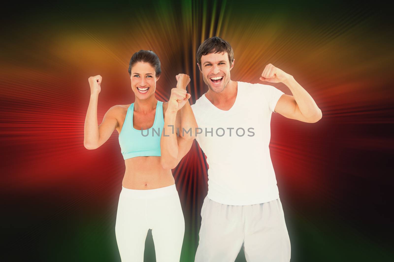 Cheerful fit couple clenching fists against abstract background