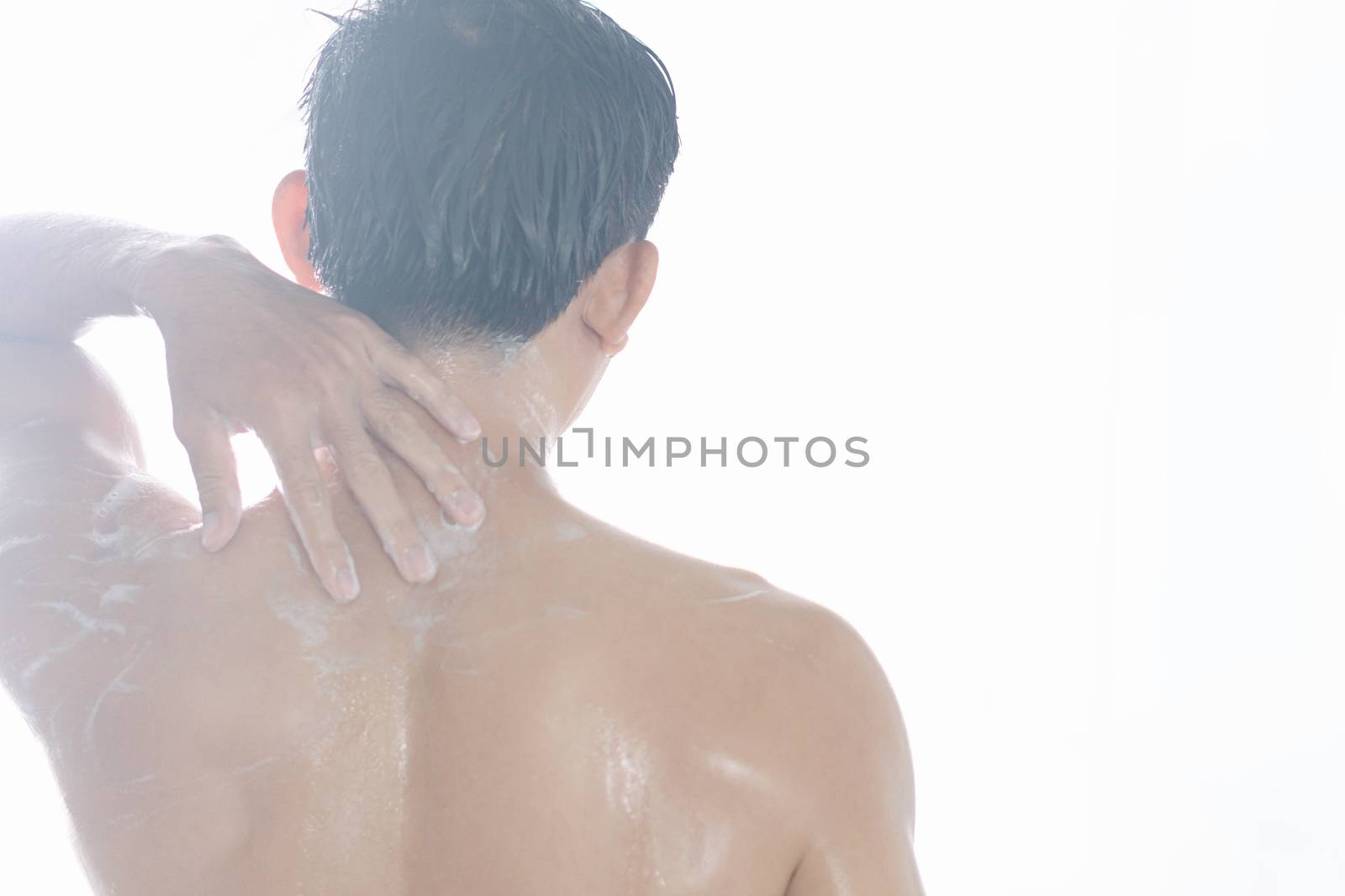 Closeup young man washing hair with with shampoo isolated on white background, vintage tone, selective focus