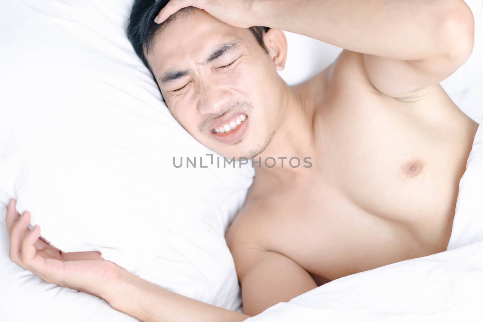 Man hand holding forehead with sick and headache lying on white bedroom, health care and medical