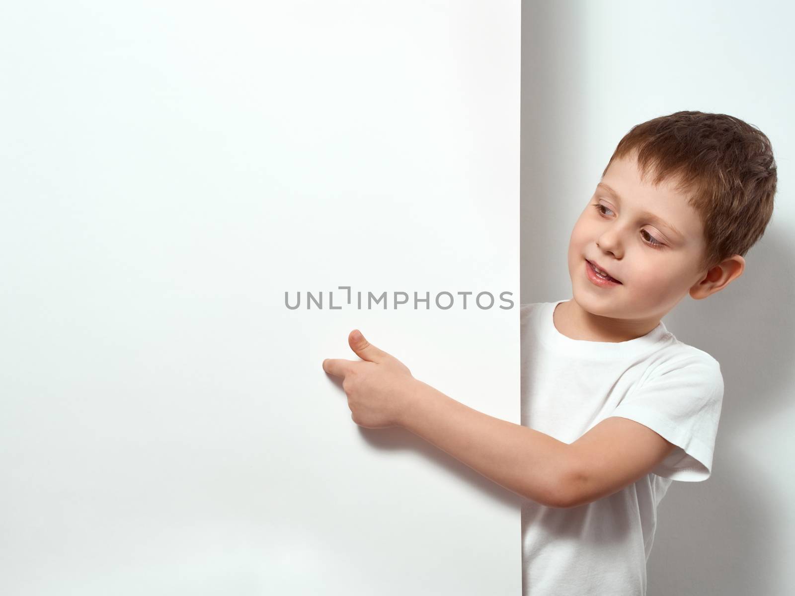 Little boy shows finger on blank sheet by fascinadora