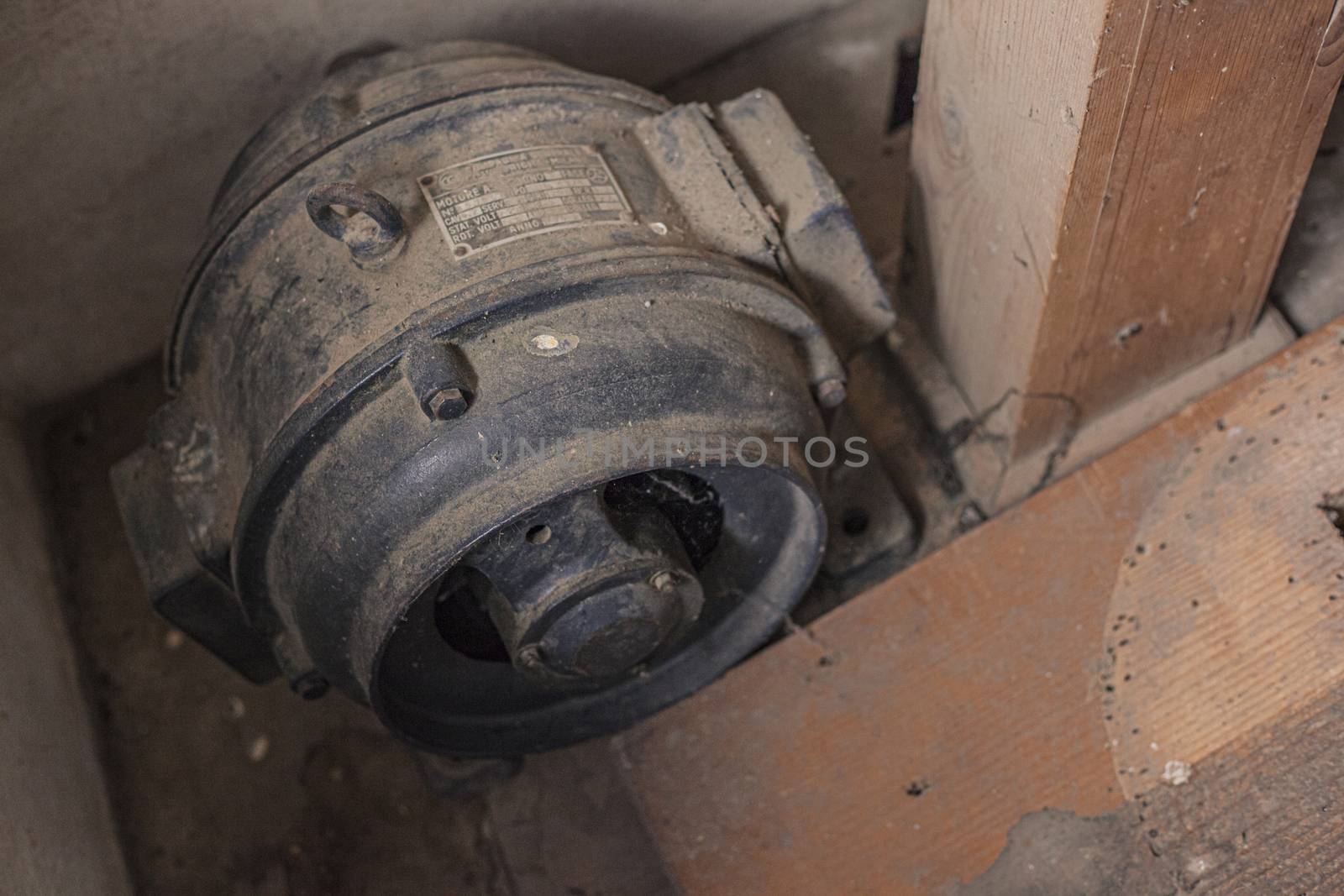 old industrial electric motor attached to the wall of an abandoned building