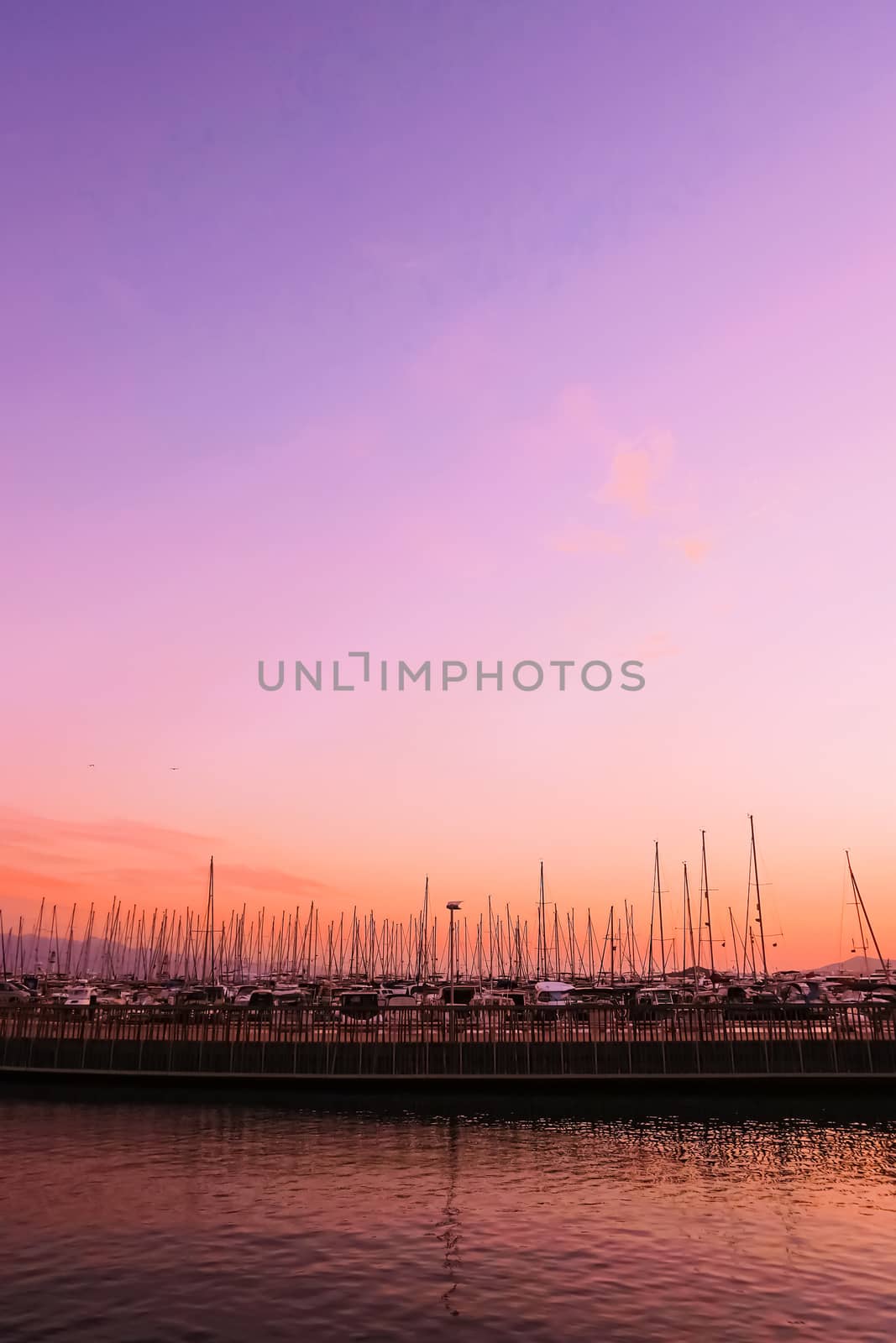 Yachts and boats in the harbor on Mediterranean sea coast at sunset, travel and leisure scene