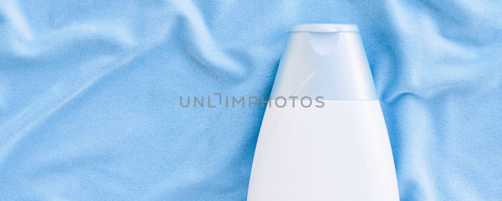 Blank label shampoo bottle or shower gel mockup on blue silk background, beauty product and body care cosmetics, flatlay