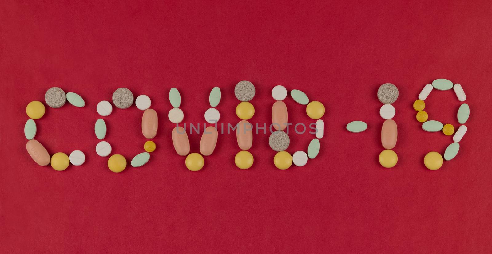 Inscription Coronavirus made from pills on a red background. Coronavirus text made of tablets. Coronavirus Protection Concept