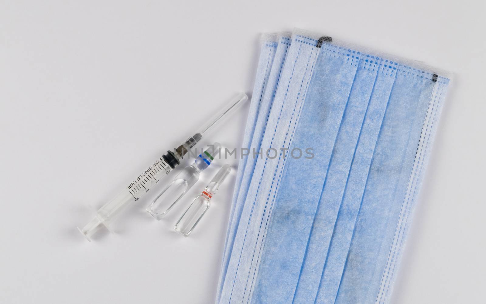 Medical protective masks on a white background with vaccine capsules and a syringe. Coronavirus Protection Concept