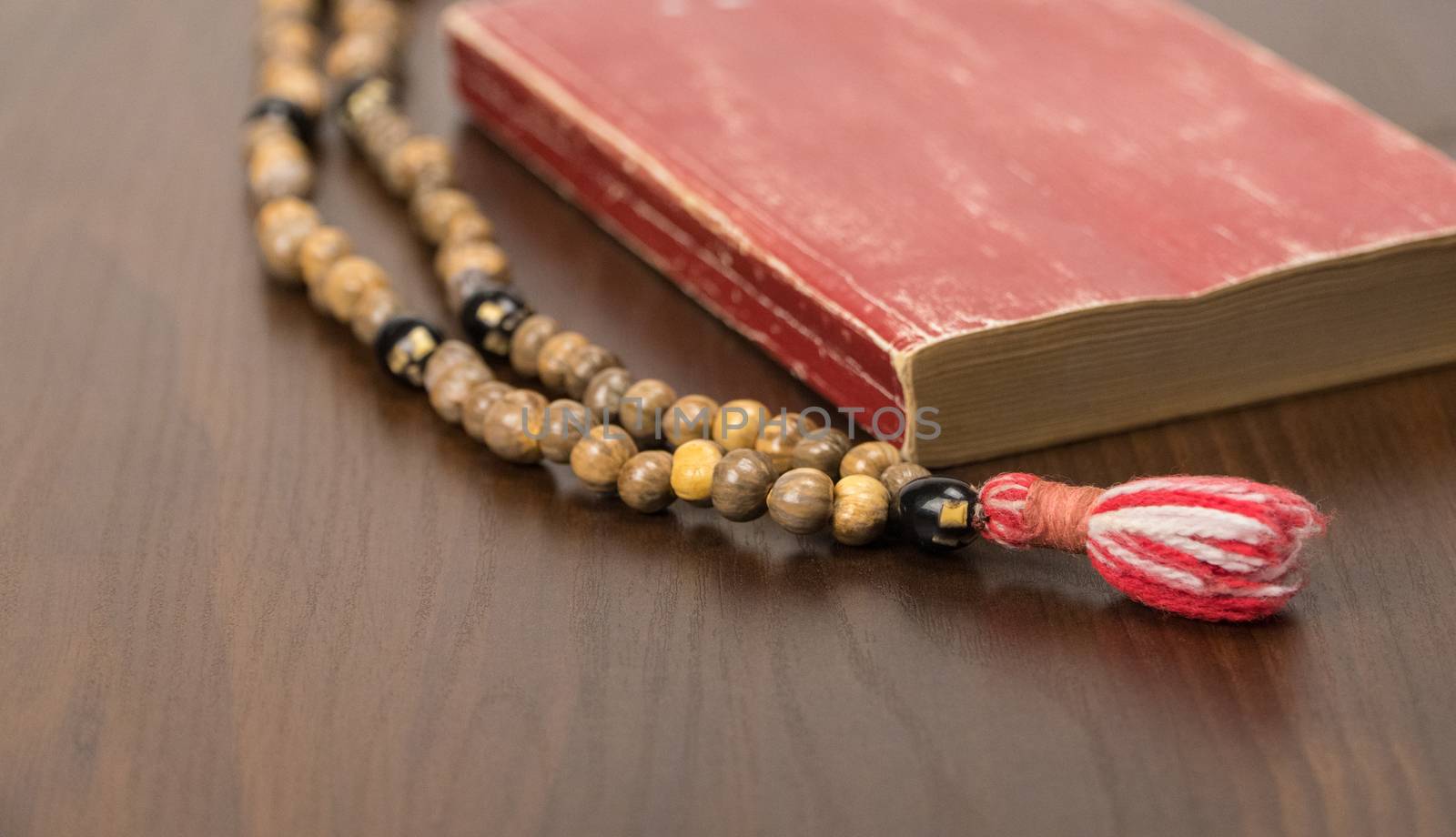 Muslim prayer beads and Koran isolated on a wooden background. Islamic and Muslim concepts