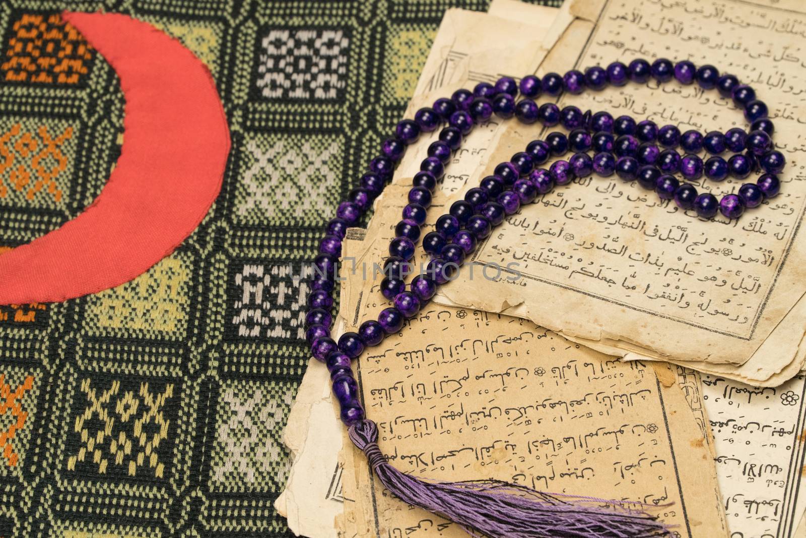 Muslim prayer beads with ancient pages from the Koran. Islamic and Muslim concepts. Ancient old sheets of paper from the Arabic book