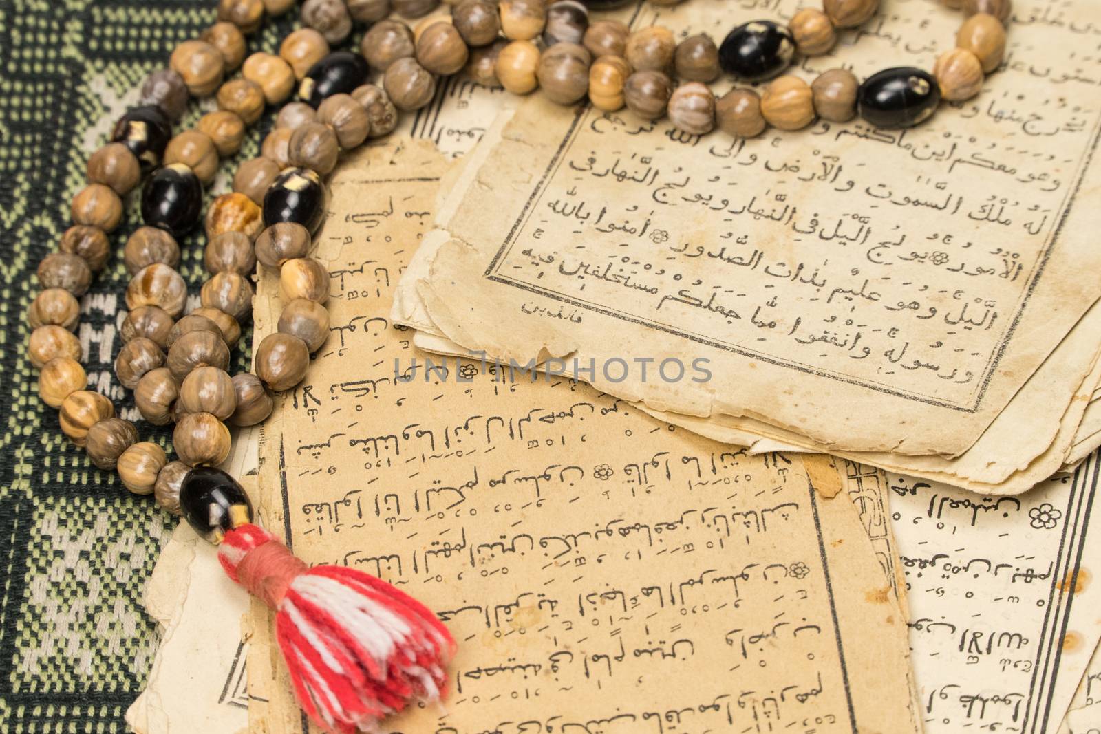 Muslim prayer beads with ancient pages from the Koran. Islamic and Muslim concepts. Ancient old sheets of paper from the Arabic book