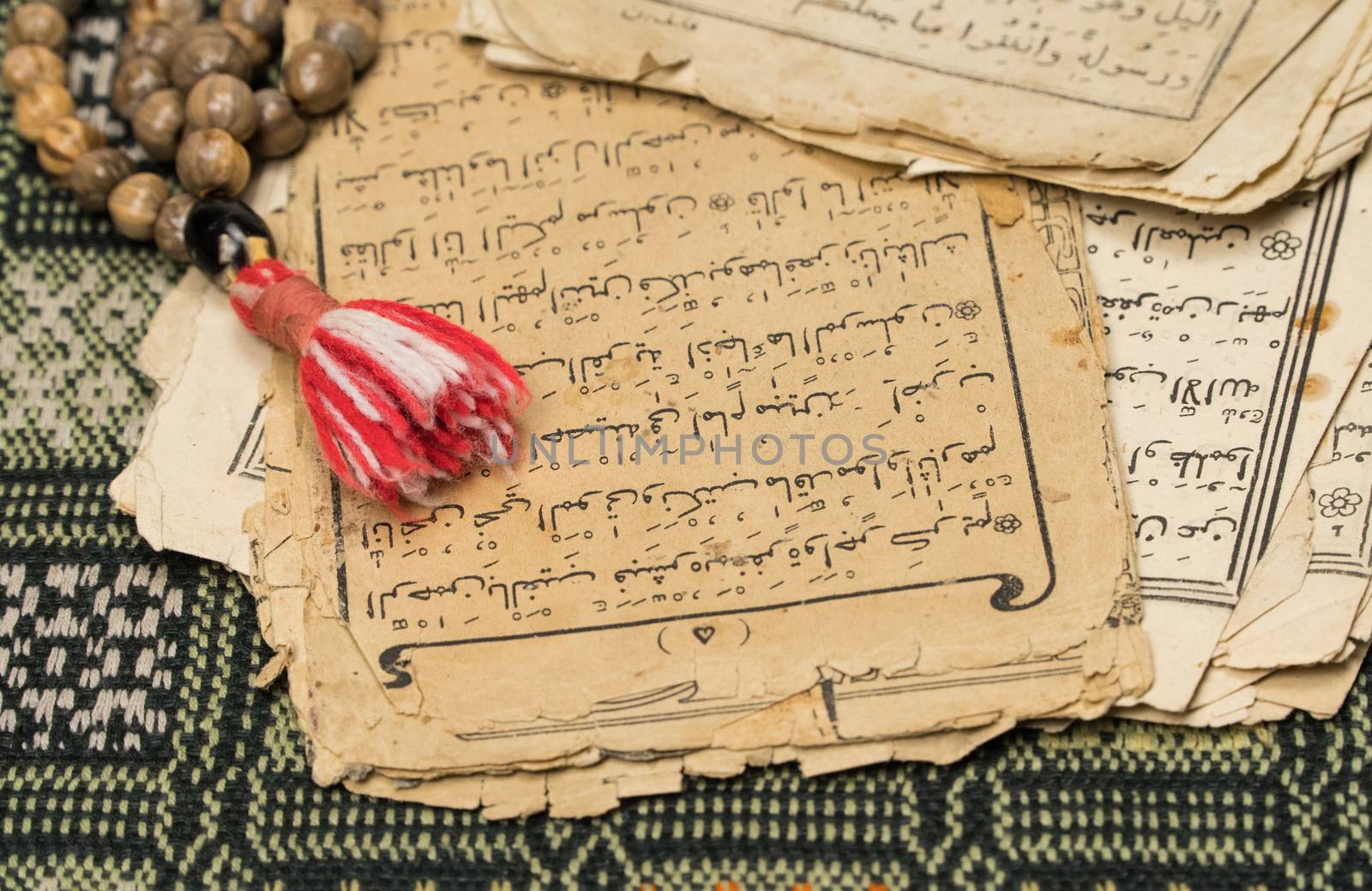 Muslim prayer beads with ancient pages from the Koran. Islamic and Muslim concepts. Ancient old sheets of paper from the Arabic book