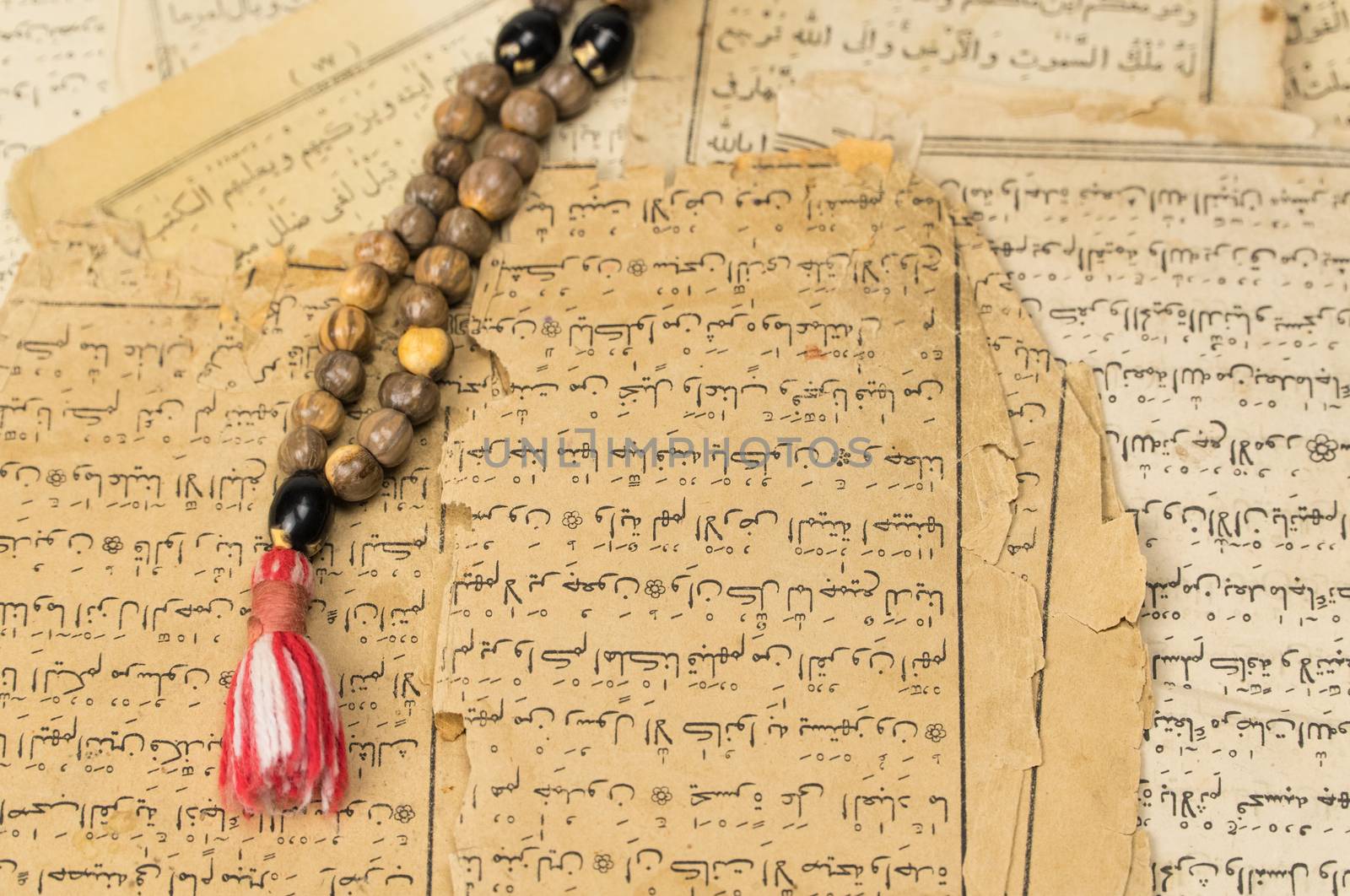 Muslim prayer beads with ancient pages from the Koran. Islamic and Muslim concepts. Ancient old sheets of paper from the Arabic book