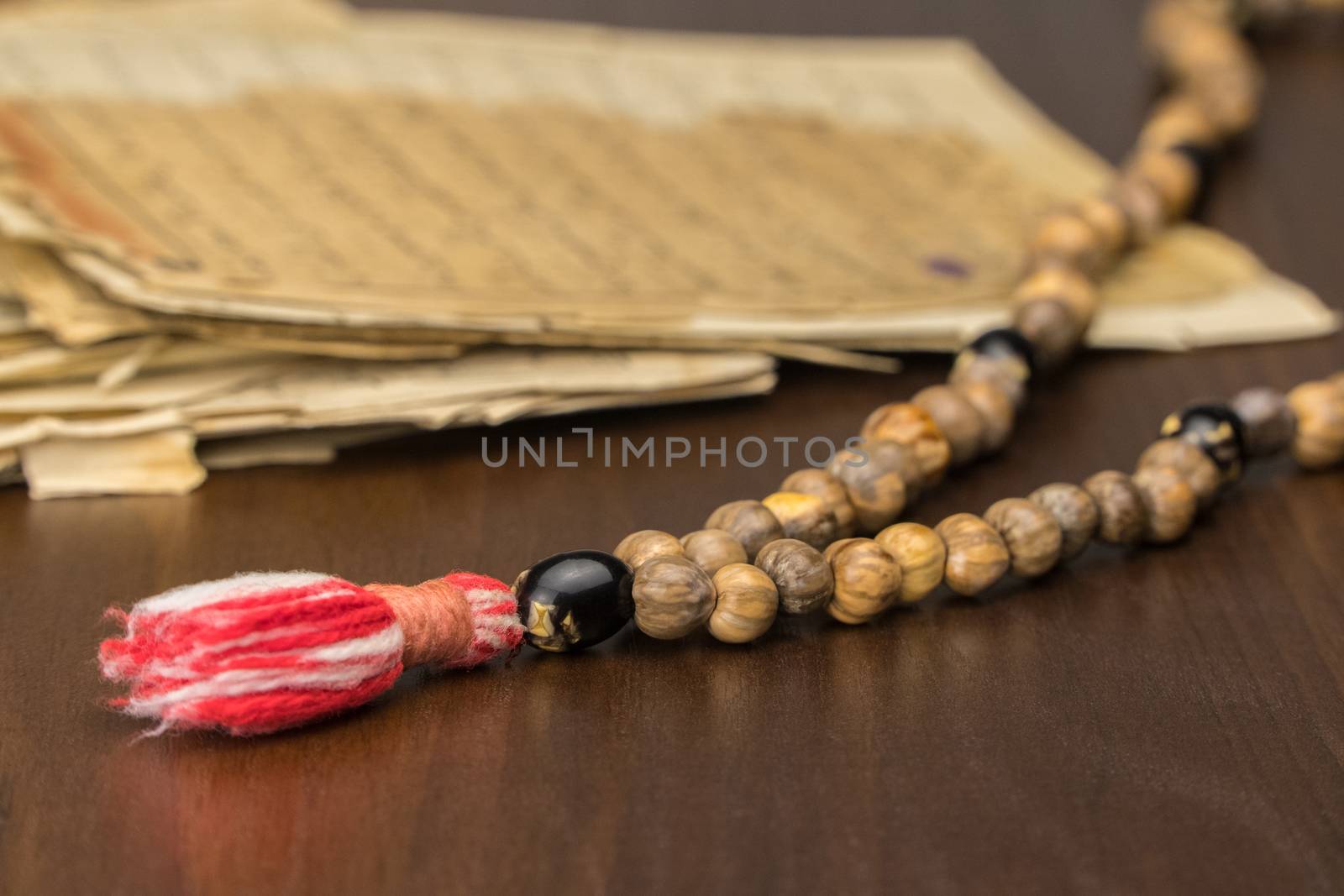 Muslim prayer beads with ancient pages from the Koran. Islamic and Muslim concepts. Ancient old sheets of paper from the Arabic book