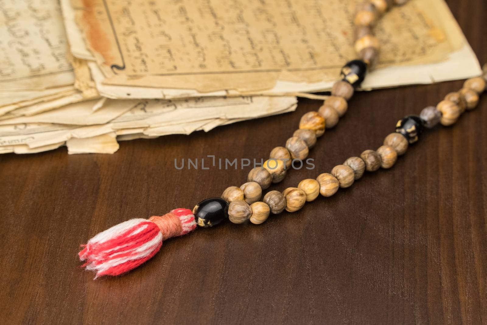 Muslim prayer beads with ancient pages from the Koran. Islamic and Muslim concepts. Ancient old sheets of paper from the Arabic book