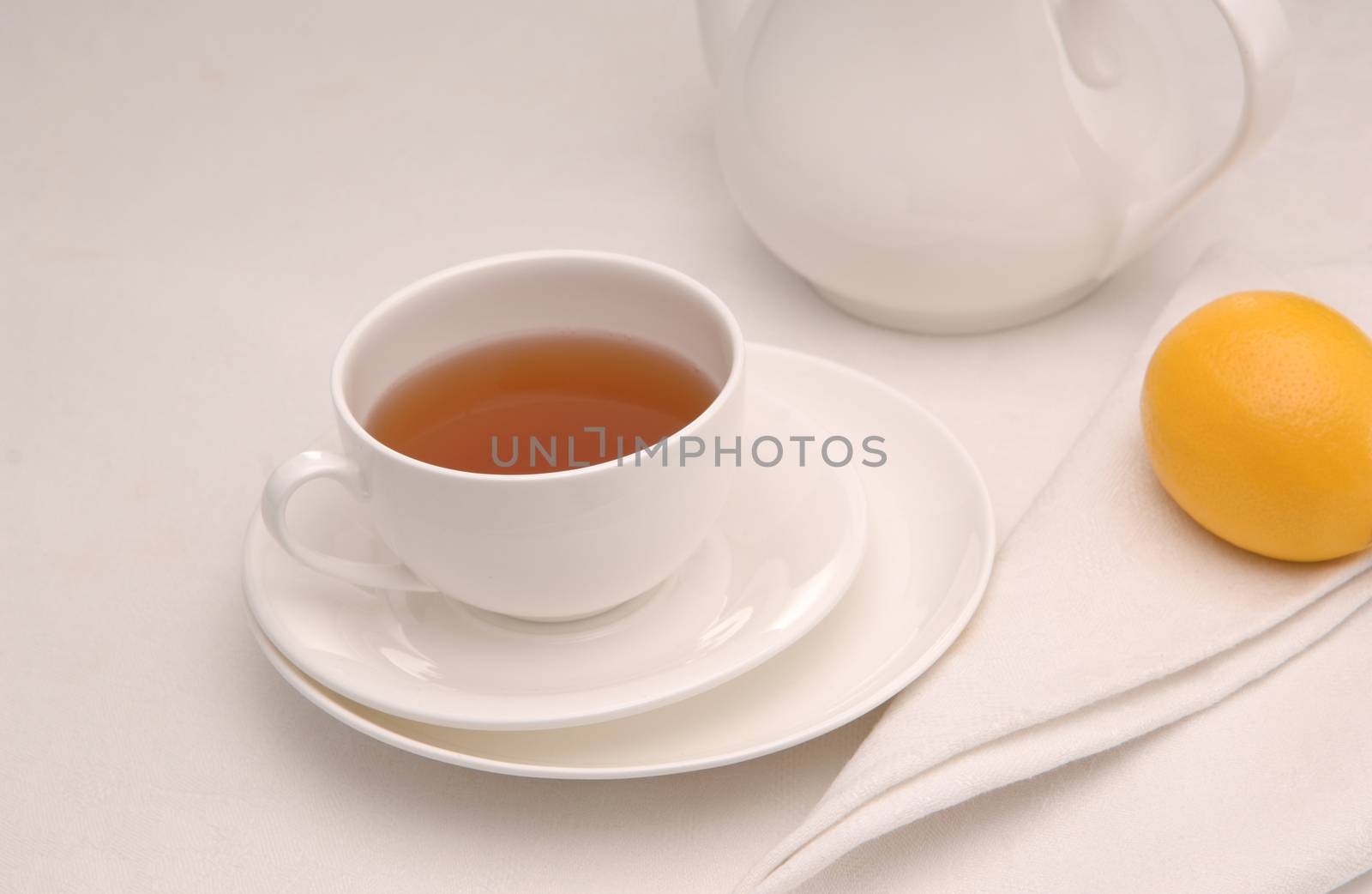 on a napkin cup of tea with lemon in a saucer and teapot