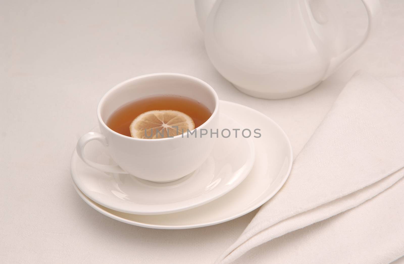 on a napkin cup of tea with lemon in a saucer and teapot