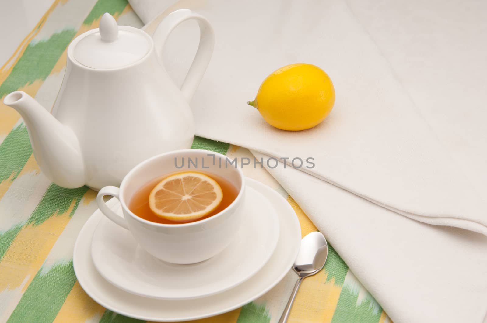 on a napkin cup of tea with lemon in a saucer and teapot