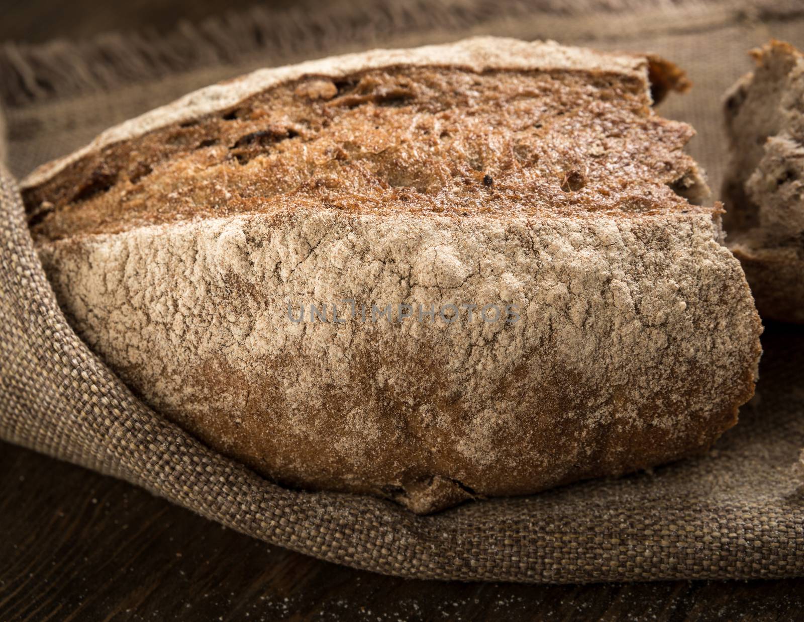 closeup of a broken loaf of bread on a cloth napkin