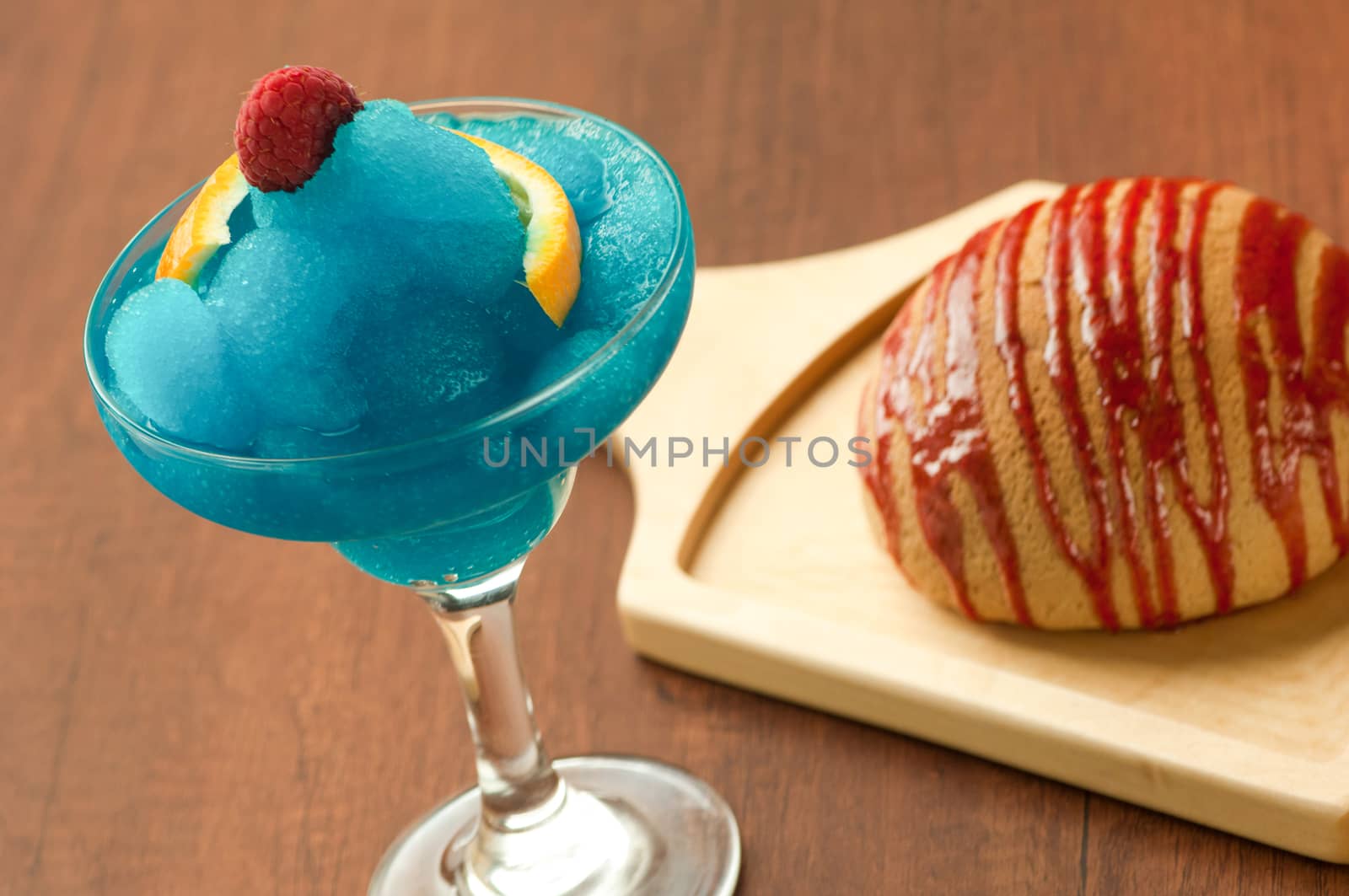 bread on a wooden plate and a glass of ice-cream with raspberry and lemon