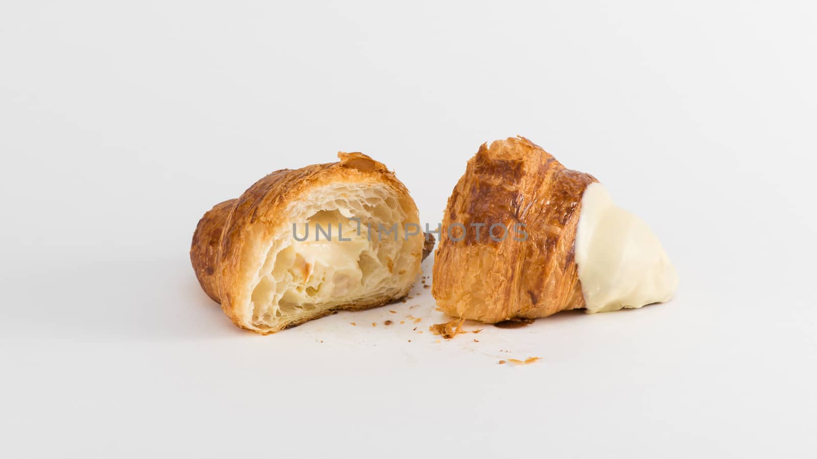 sliced croissant with cream filling on a white background