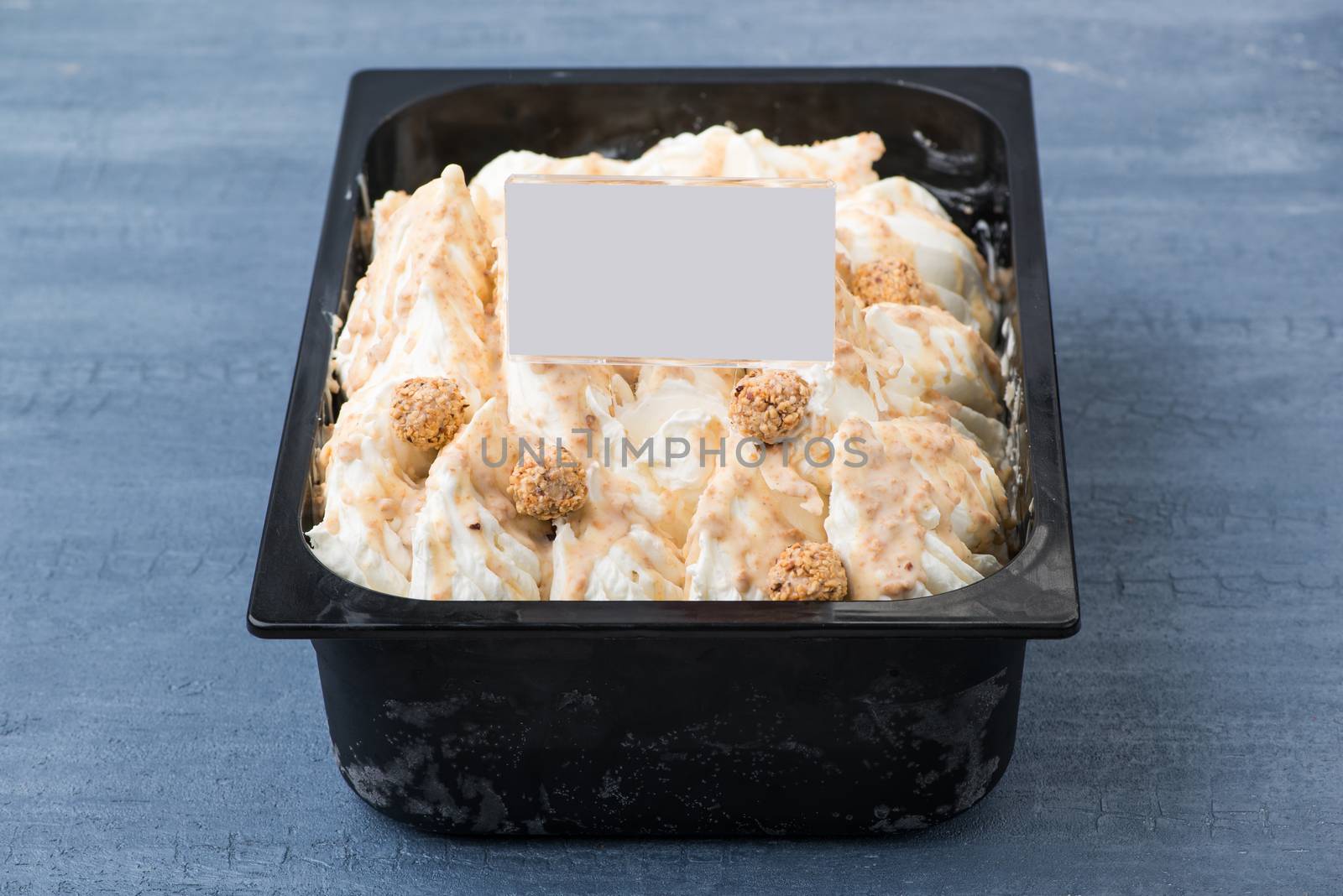 appetizing ice cream in a plastic container with a price tag on a decorative blue background